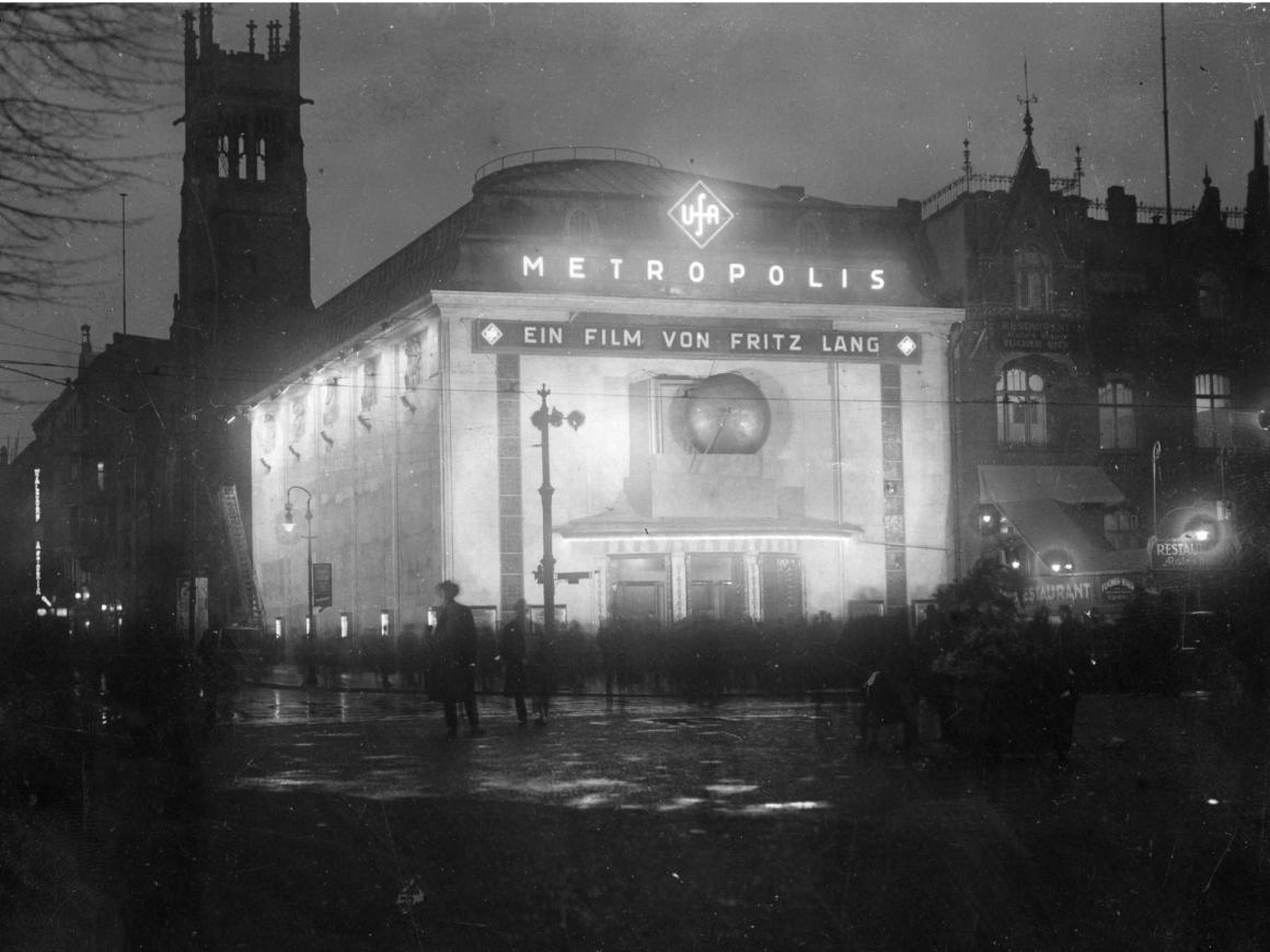 El exterior de un cine bien iluminado que muestra 'Metrópolis de Fritz Lang en 1927 en Vahamorf Platz, Berlín.