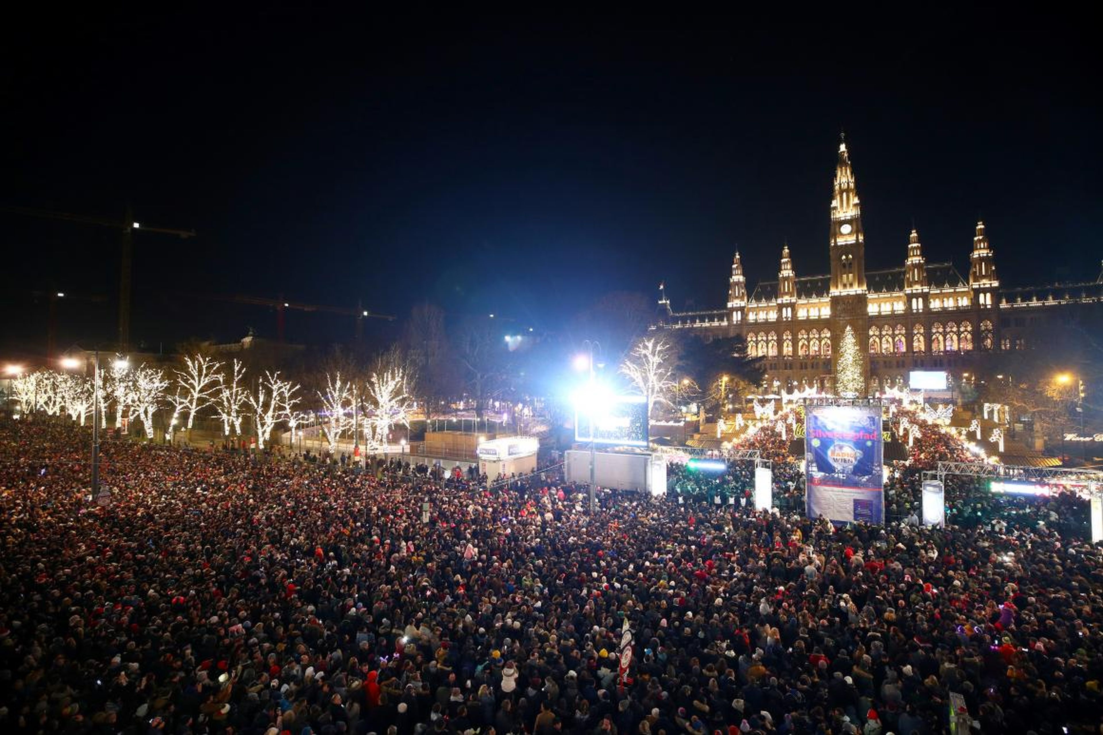 Los espectadores esperan a los fuegos artificiales en el ayuntamiento de Viena durante las celebraciones de Nochevieja en el 'Wiener Silvesterpfad' en Viena, Austria, el 31 de diciembre de 2018.