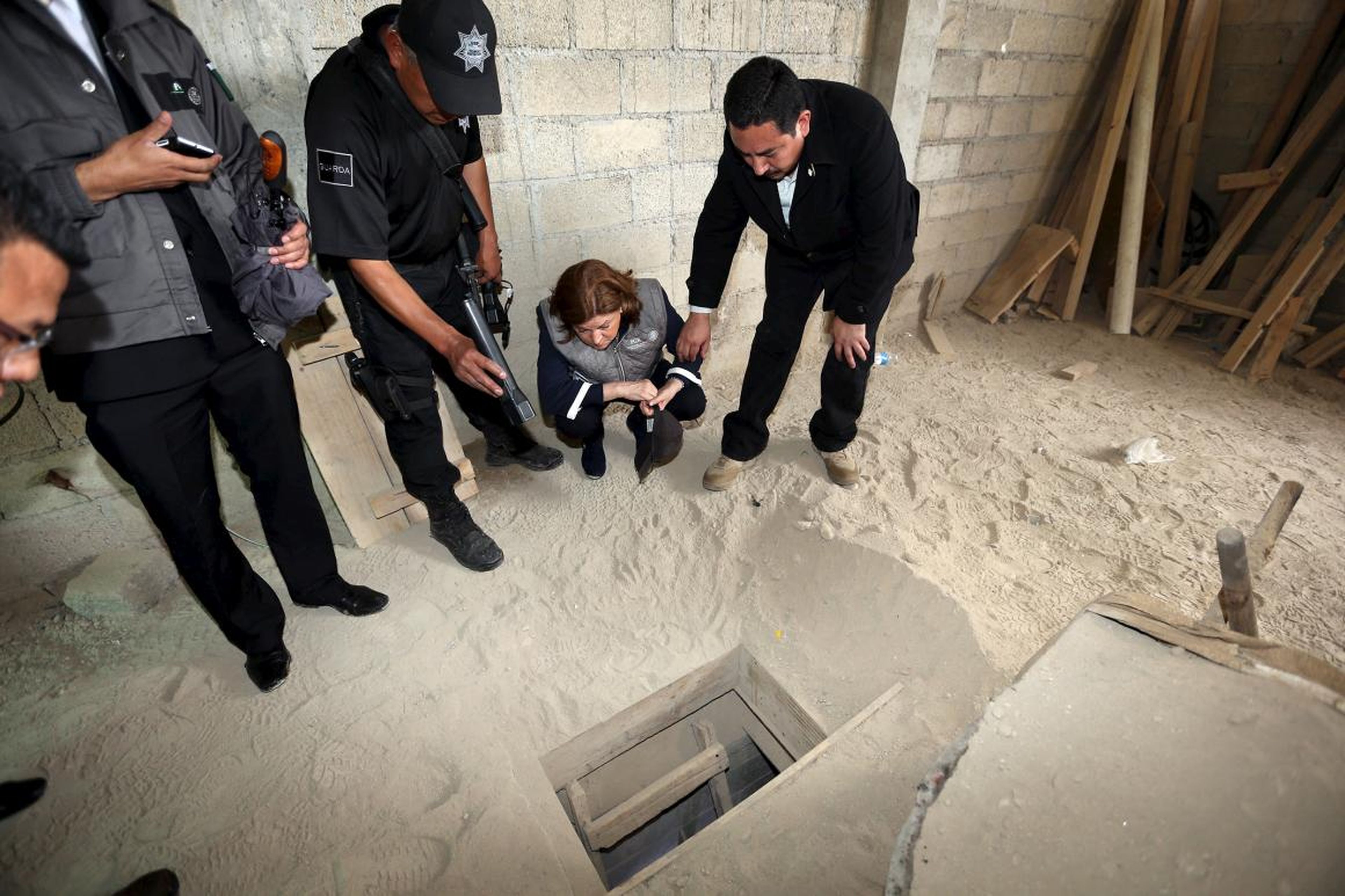 Mexican officials on July 12, 2015, look into the entrance of an escape tunnel used by Guzman.