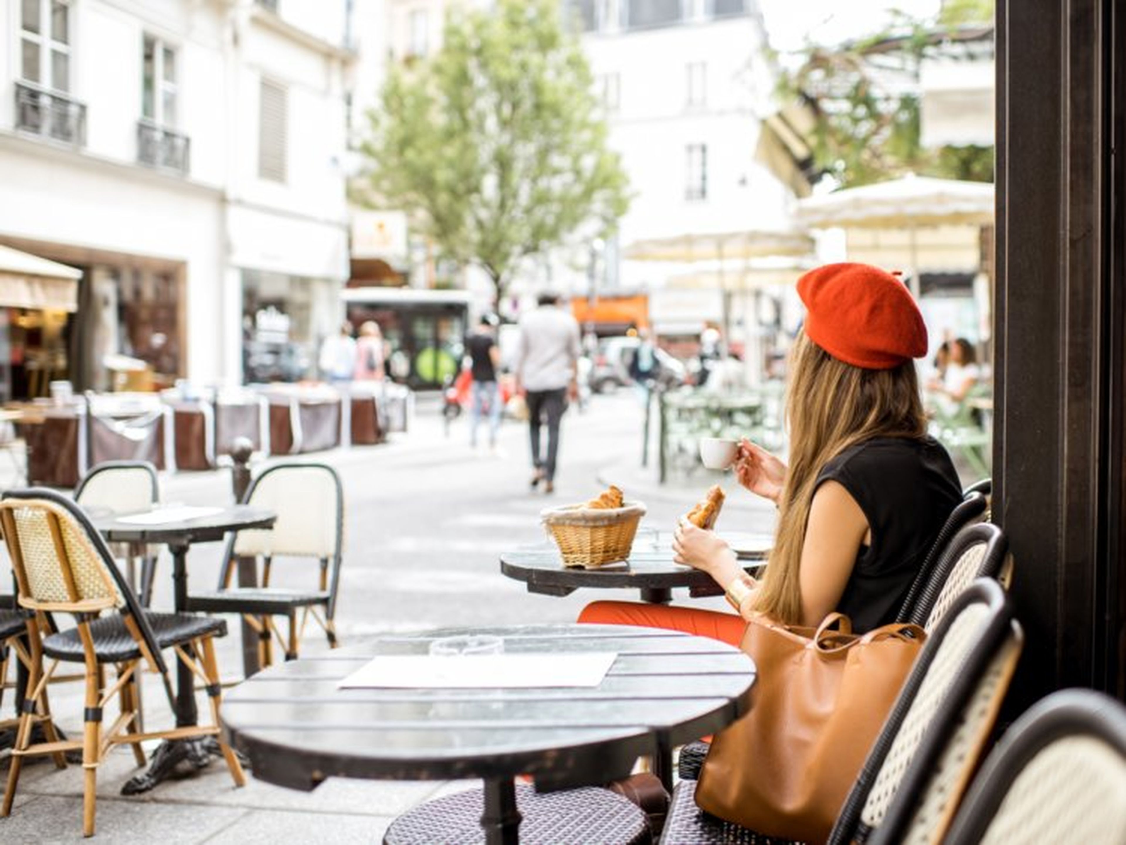 Chica se toma un café en una terraza en Francia