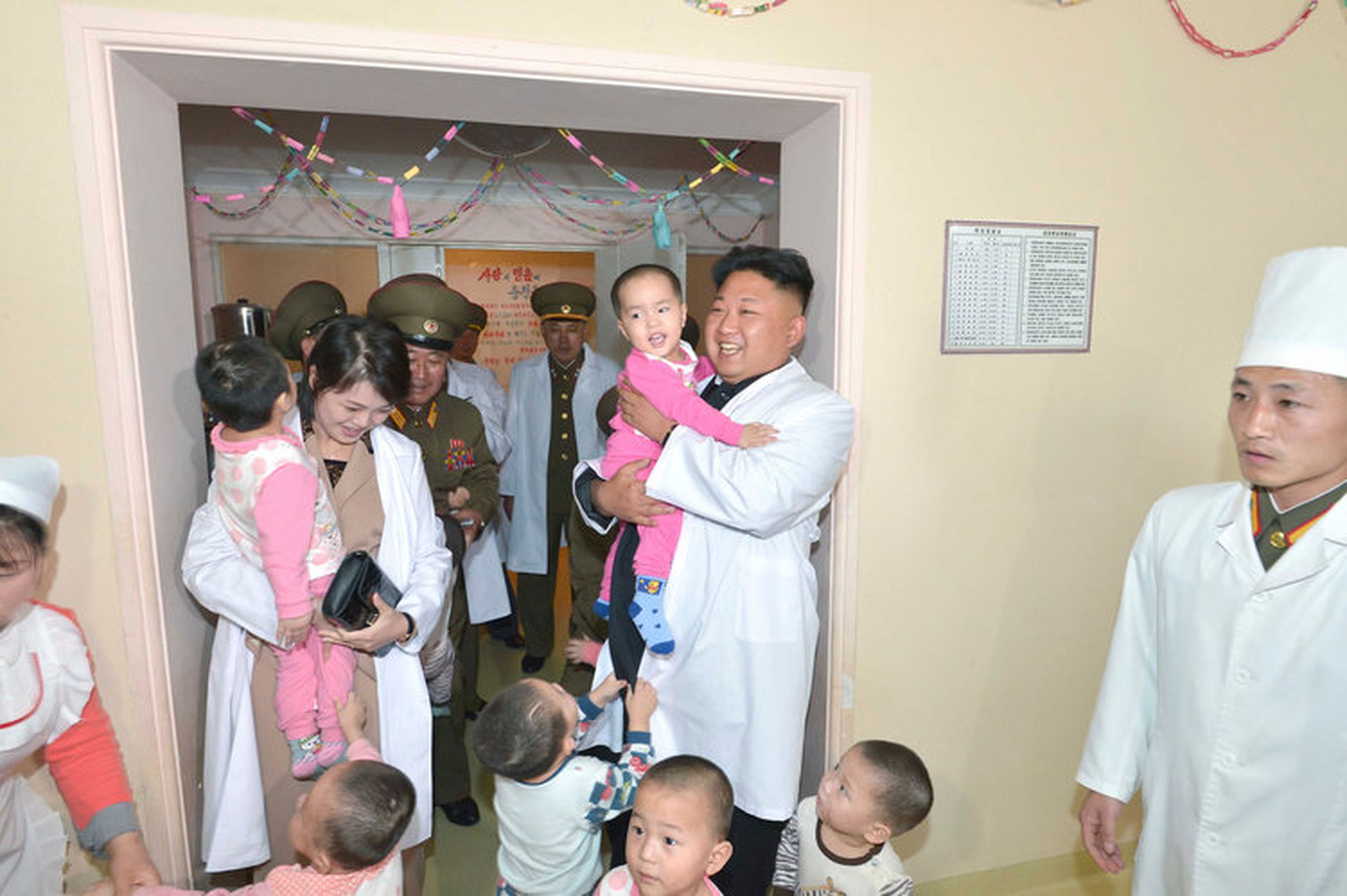 Kim y Ri juegan con niños durante una visita al hospital Taesongsan en Pyongyang en esta fotografía sin fecha publicada por la KCNA el 19 de mayo de 2014.