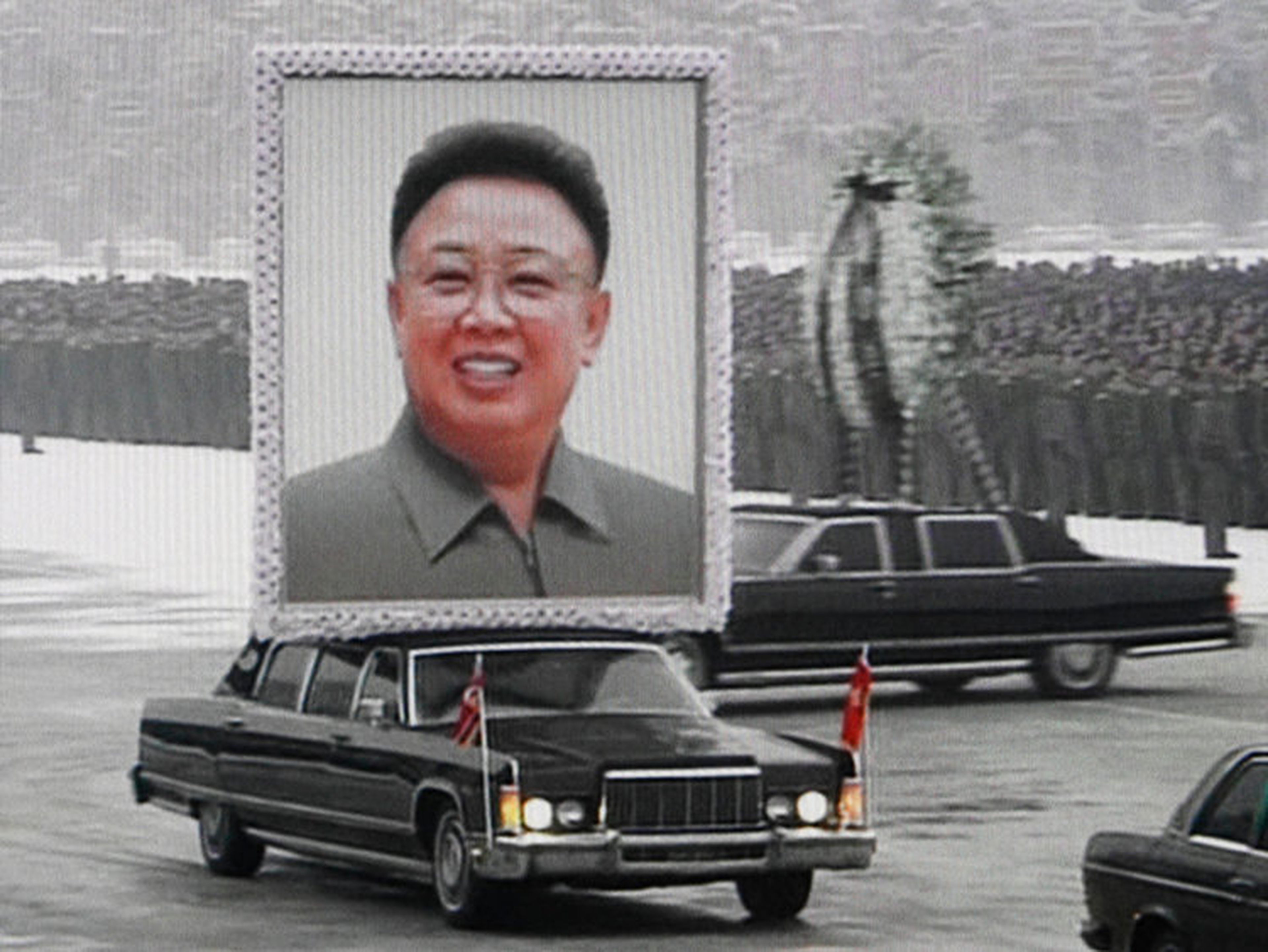 Una limusina transporta un retrato de Kim Jon-il liderando la procesión de su funeral entre las masas en una calle en Pyongyang en esta imagen sacada de un video del 28 de diciembre de 2011.
