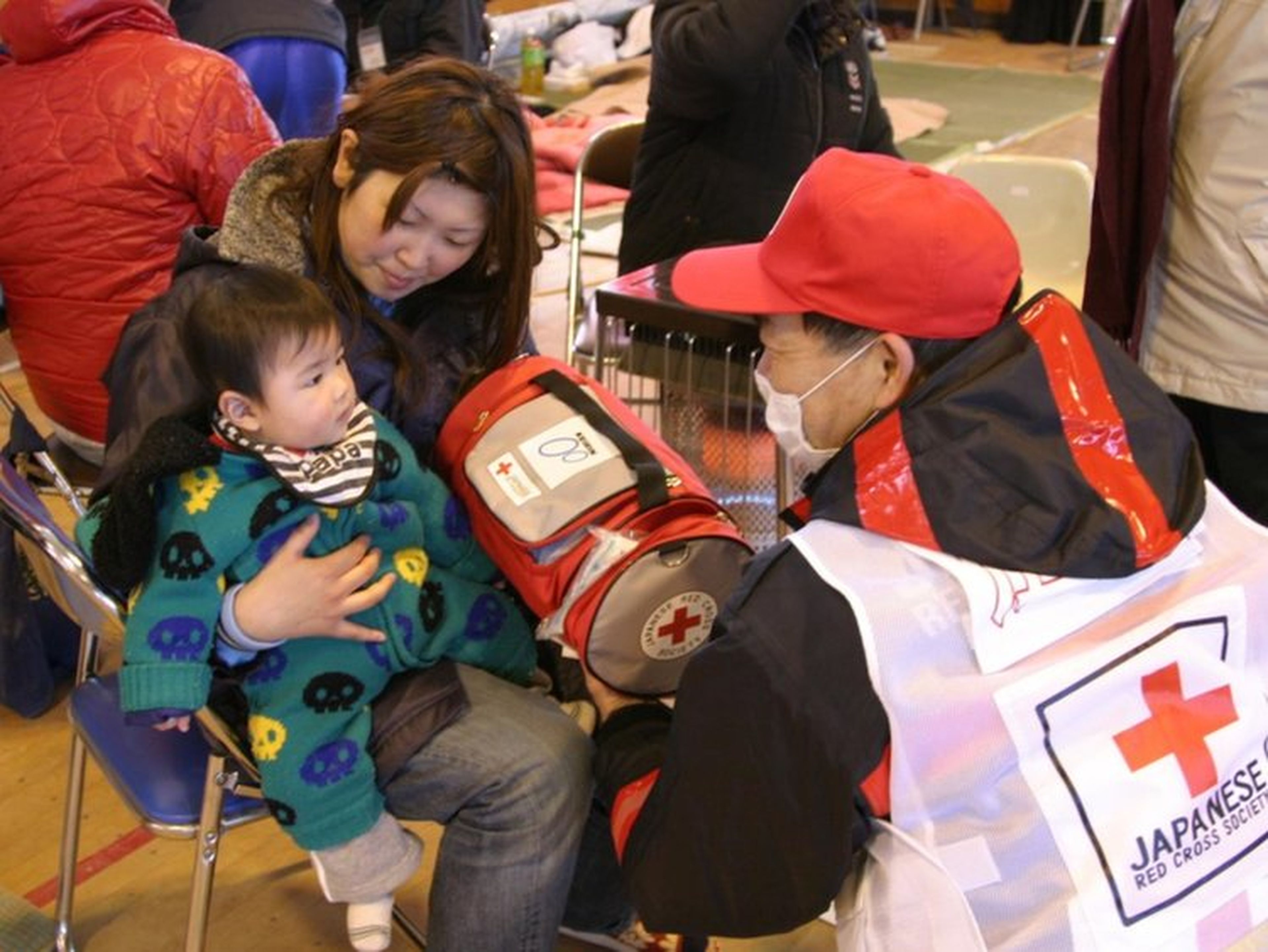 Un miembro de la cruz roja ayuda a un niño