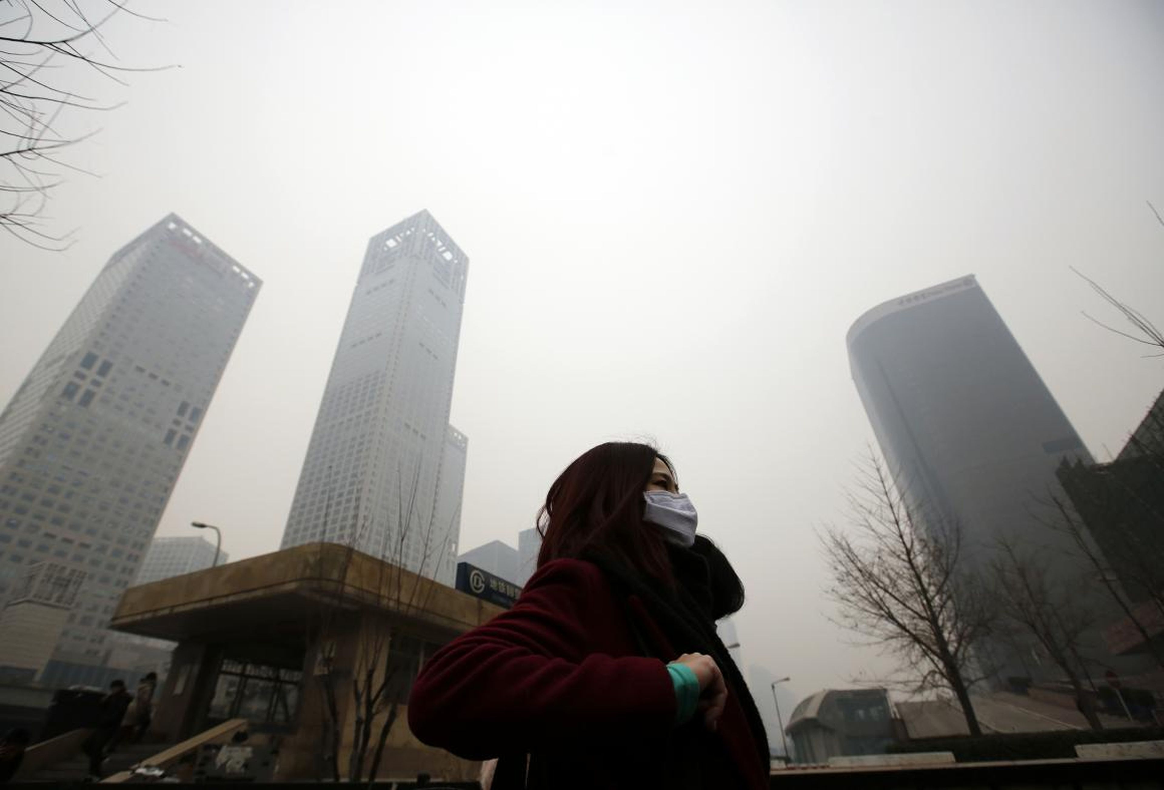 A woman makes her way through a heavy haze in Beijing.