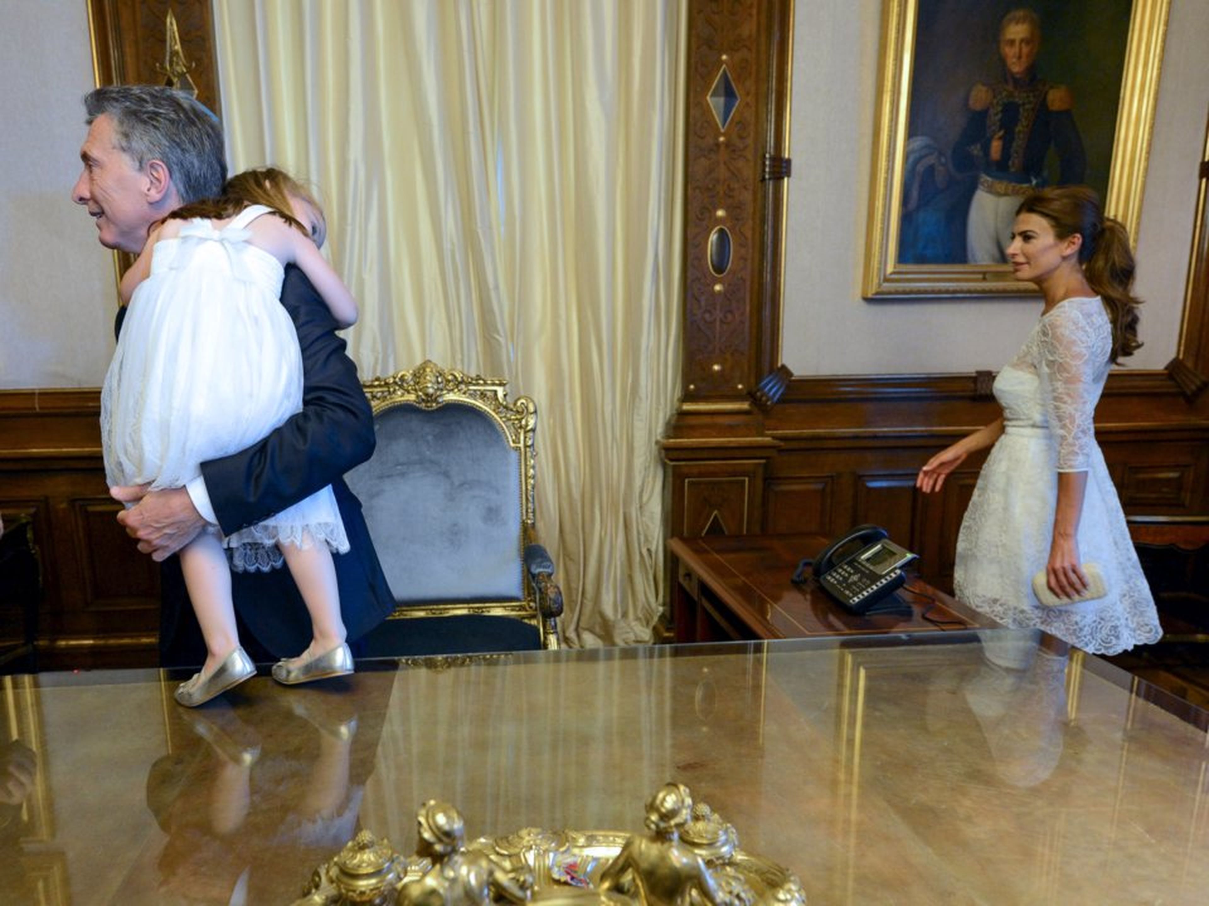 El presidente de Argentina, Mauricio Macri, lleva a su hija Antonia en brazos, seguido por su esposa Awada en el palacio presidencial de la Casa Rosada en Buenos Aires.