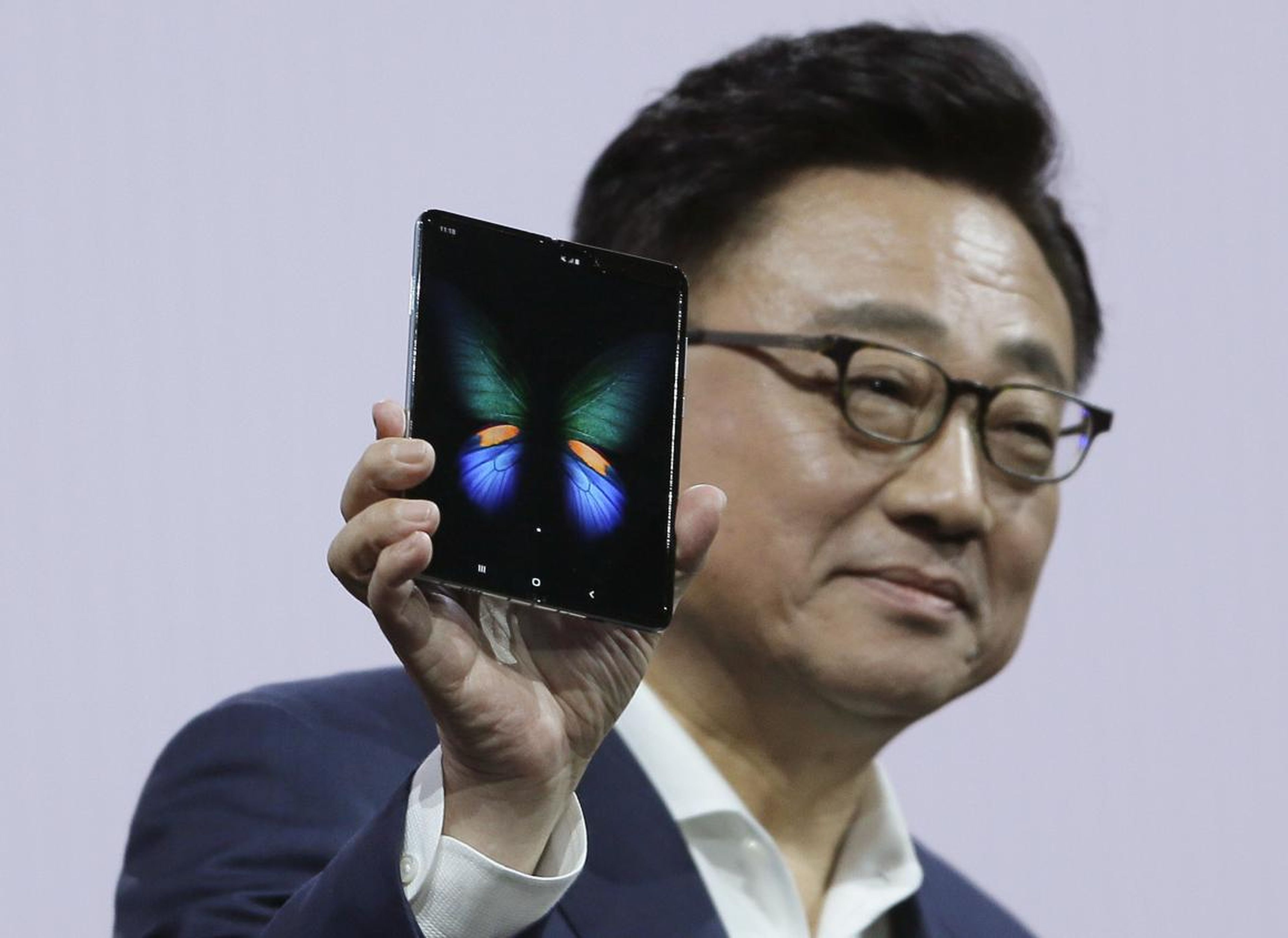 DJ Koh, the president and CEO of IT and mobile communications at Samsung, holding up the new Galaxy Fold smartphone during Samsung's Unpacked event.