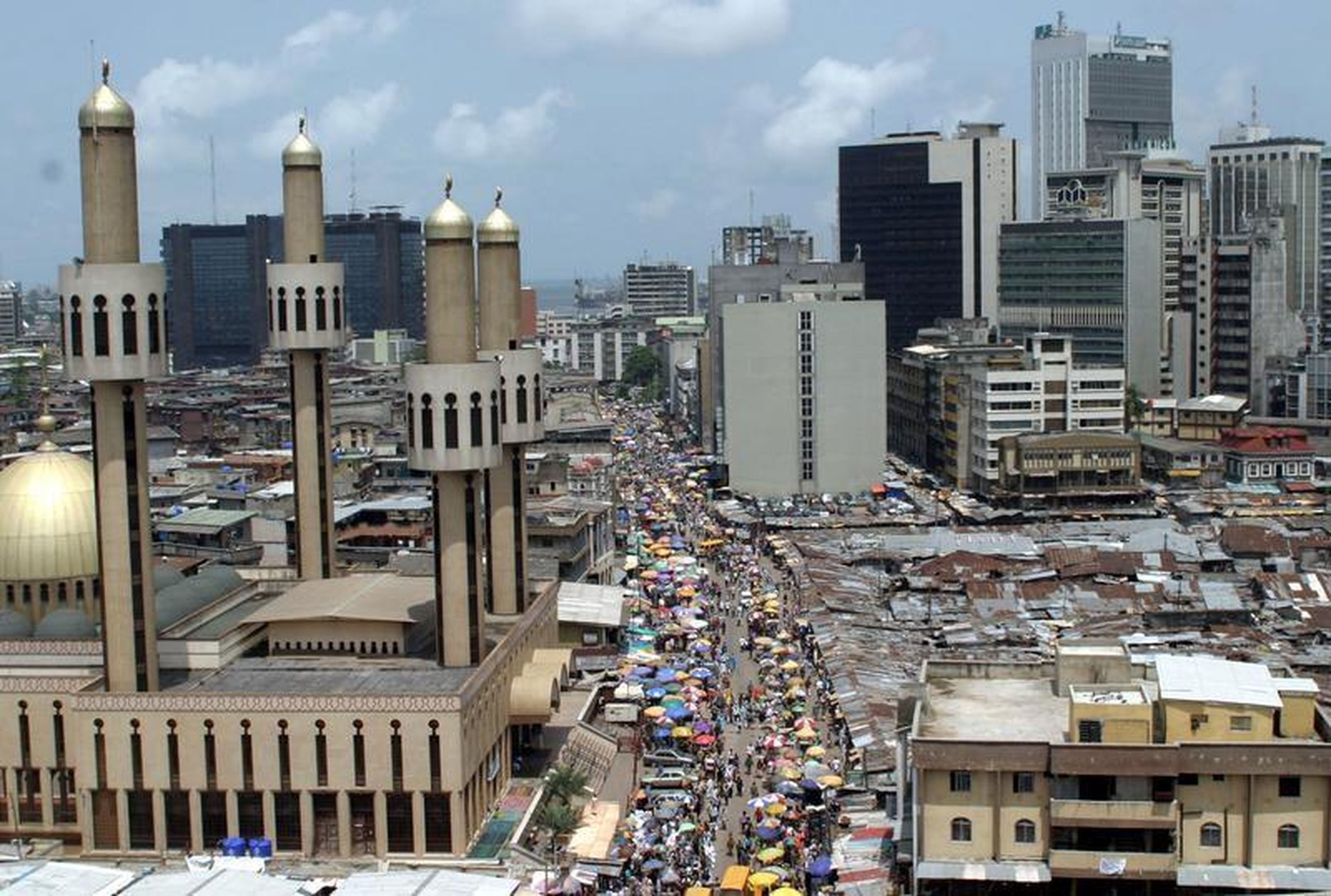 People and traffic move along a busy street in Lagos.