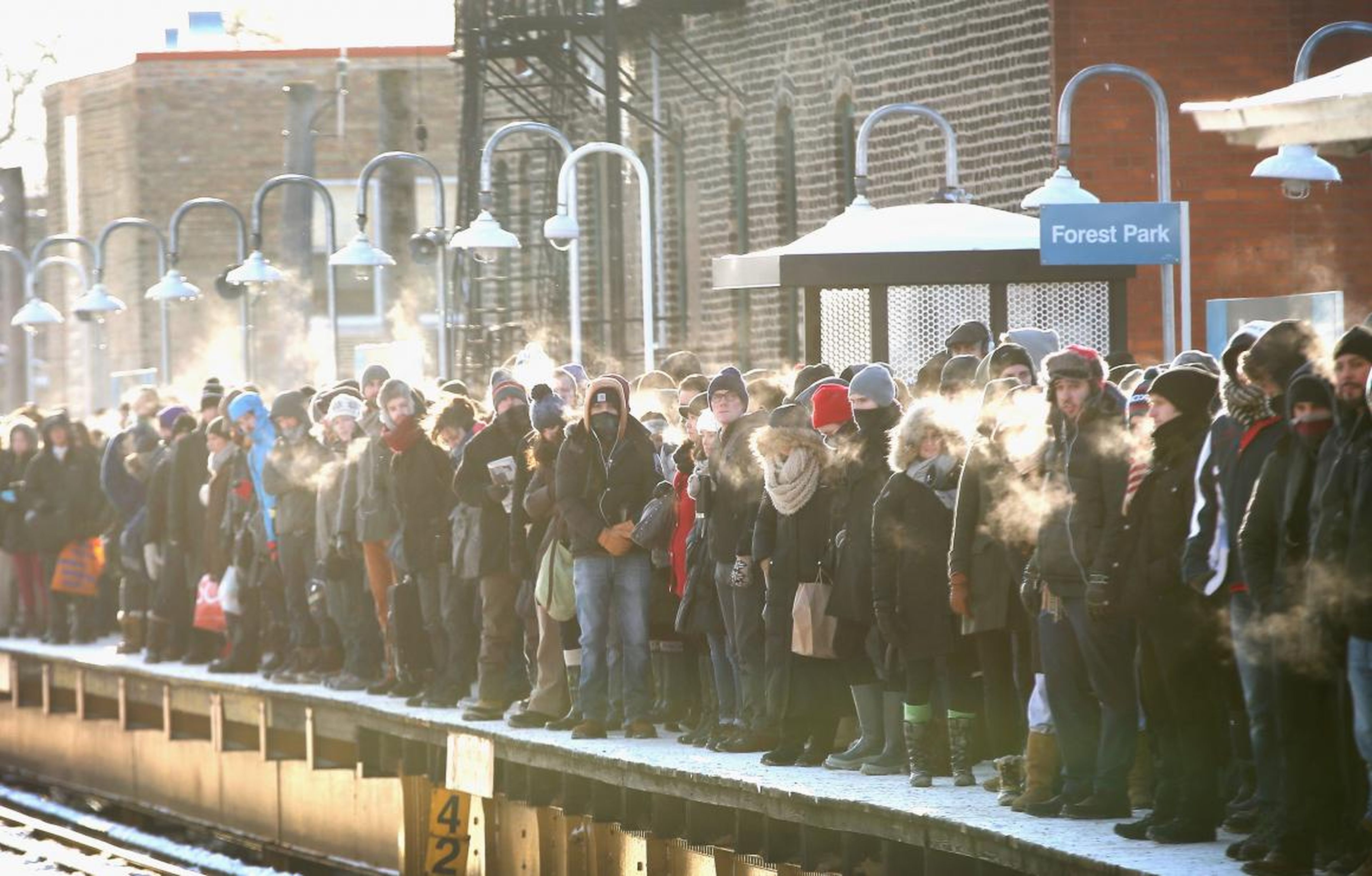 Los pasajeros que se dirigen al centro de la ciudad esperan a que el tren llegue a temperaturas por debajo de cero grados el 7 de enero de 2014 en Chicago.