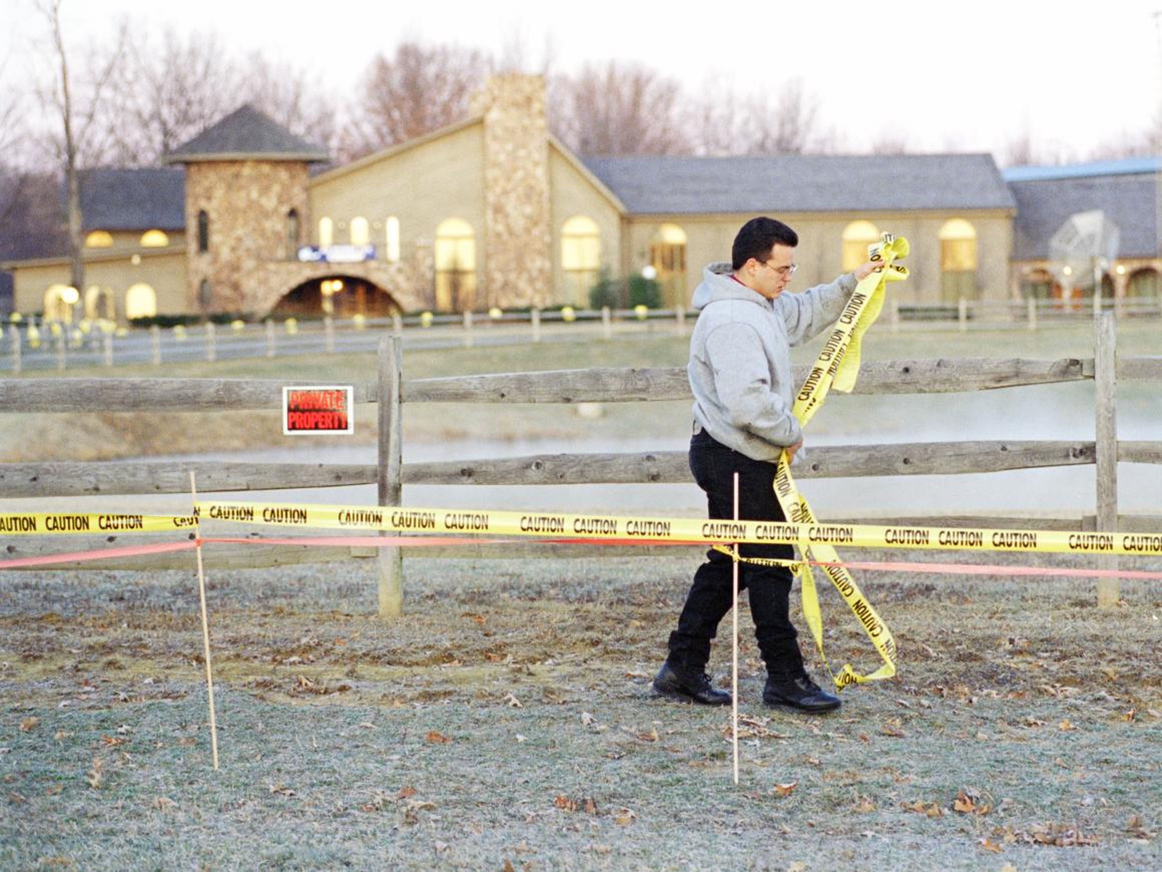 An unidentified man strings caution tape in front of the home of Mike Tyson near Southington, Ohio,