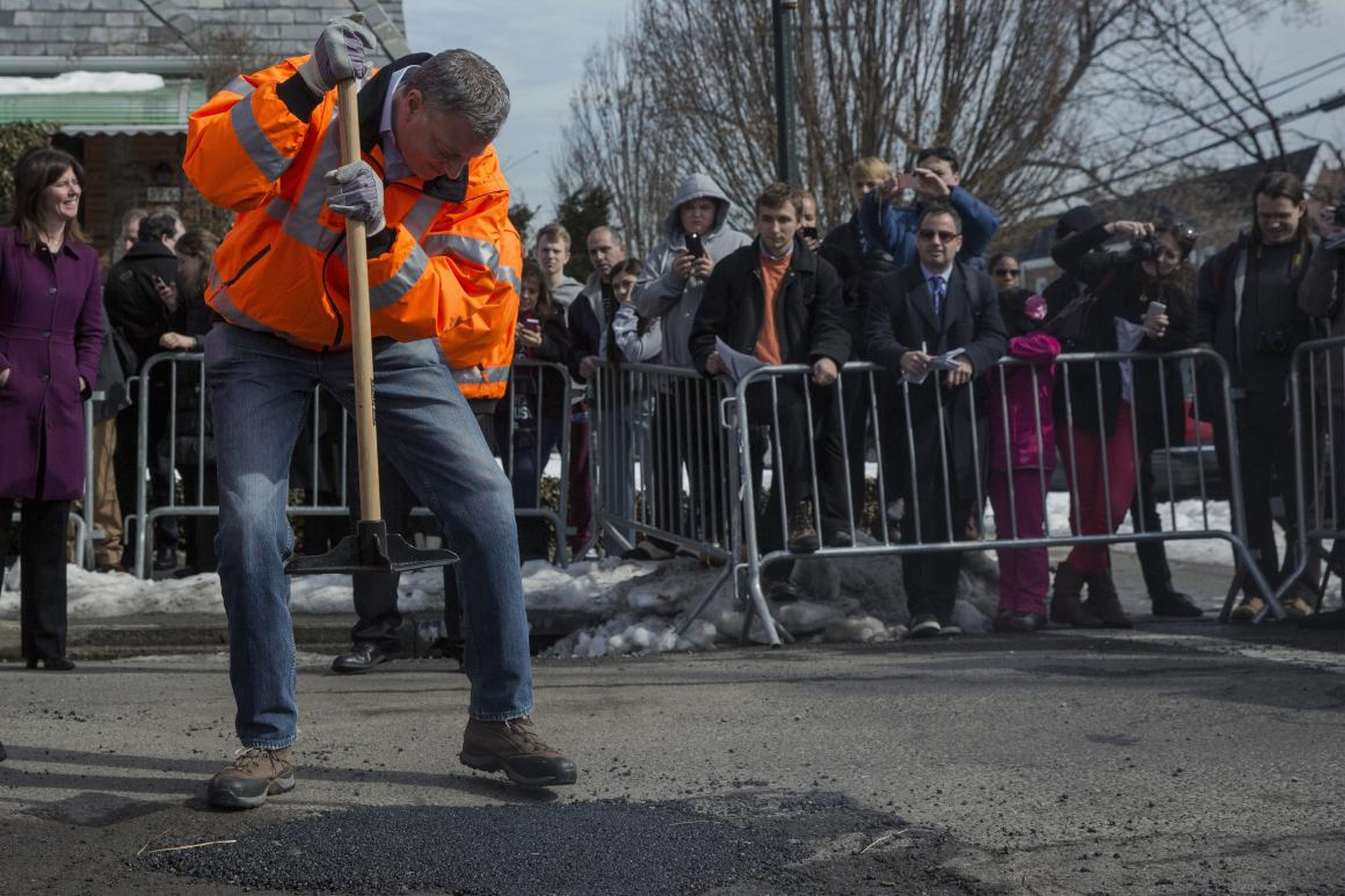 New York Mayor Bill de Blasio fills a pothole in Queens.