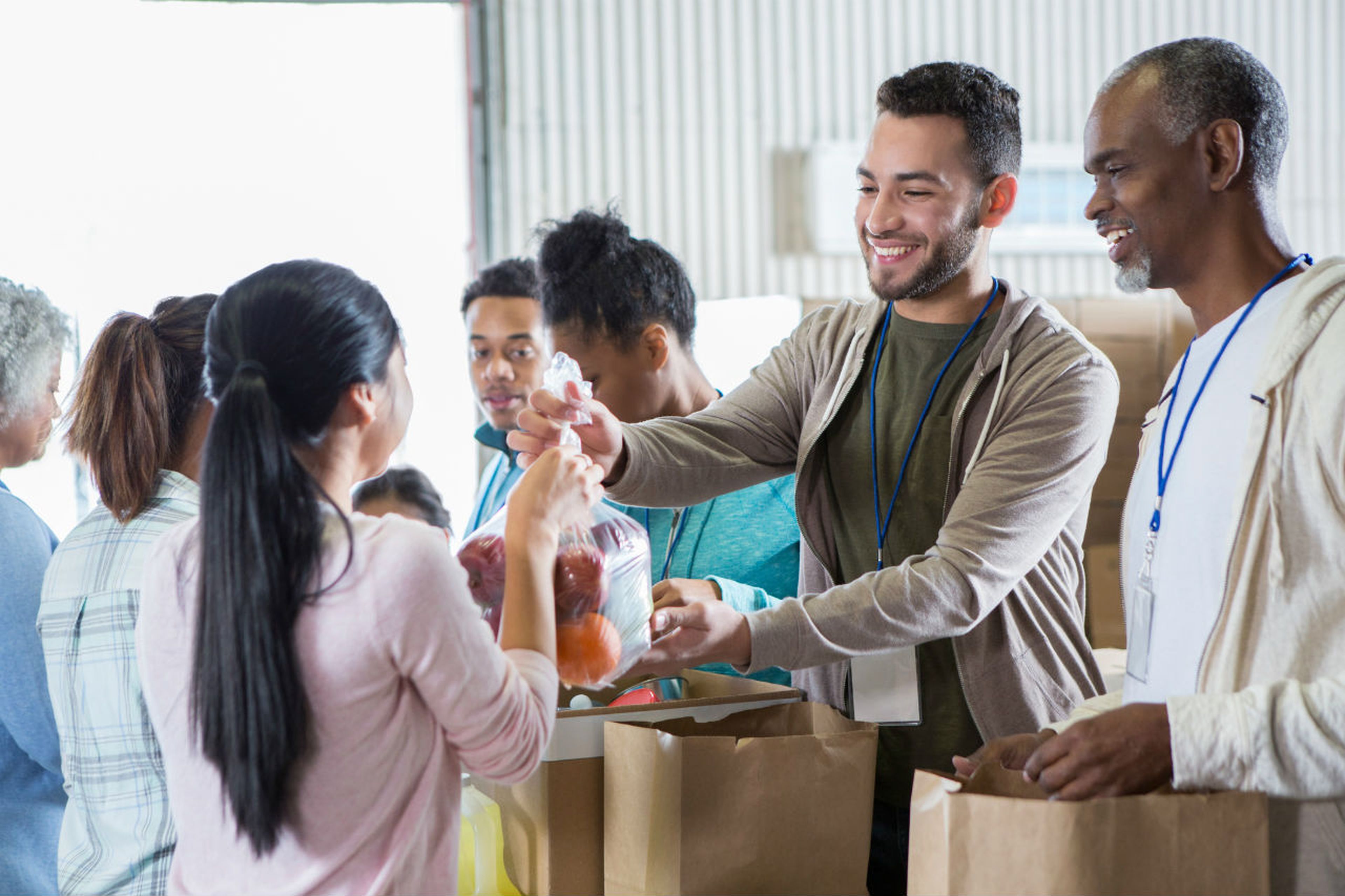 Voluntarios reparten comida en un banco de alimentos