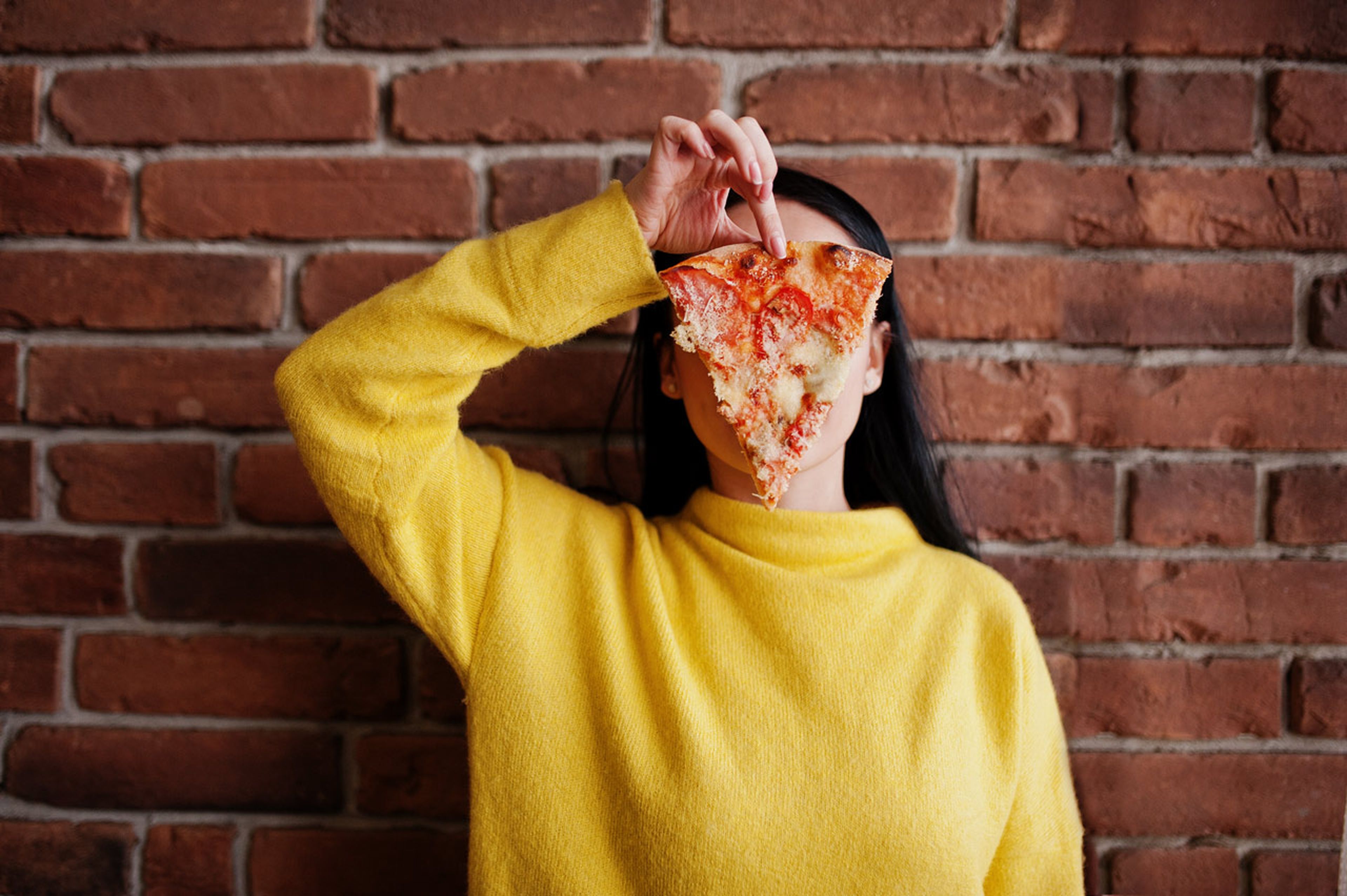 Una chica comiendo pizza