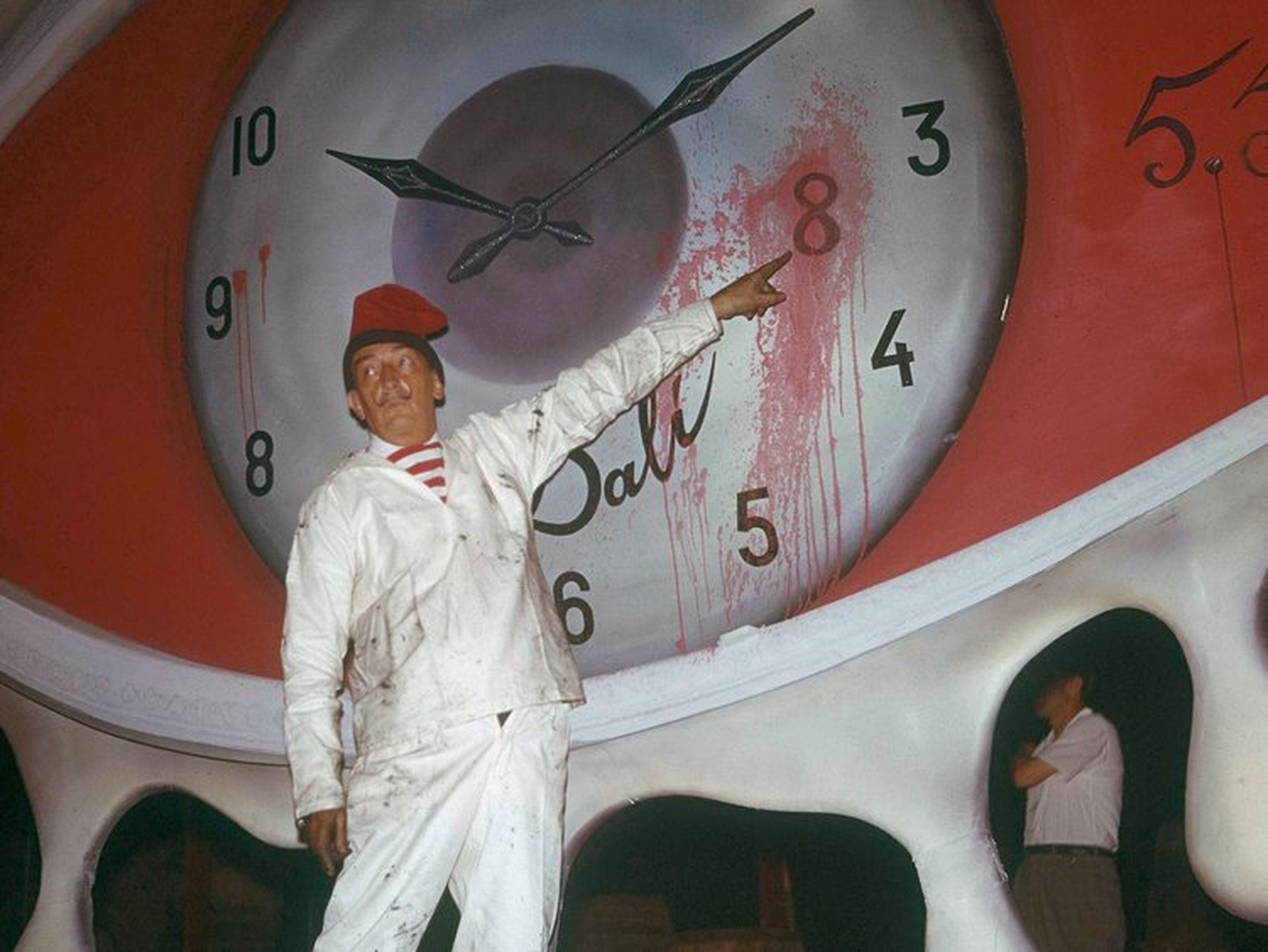 un hombre señala una pintura del reloj de Dali