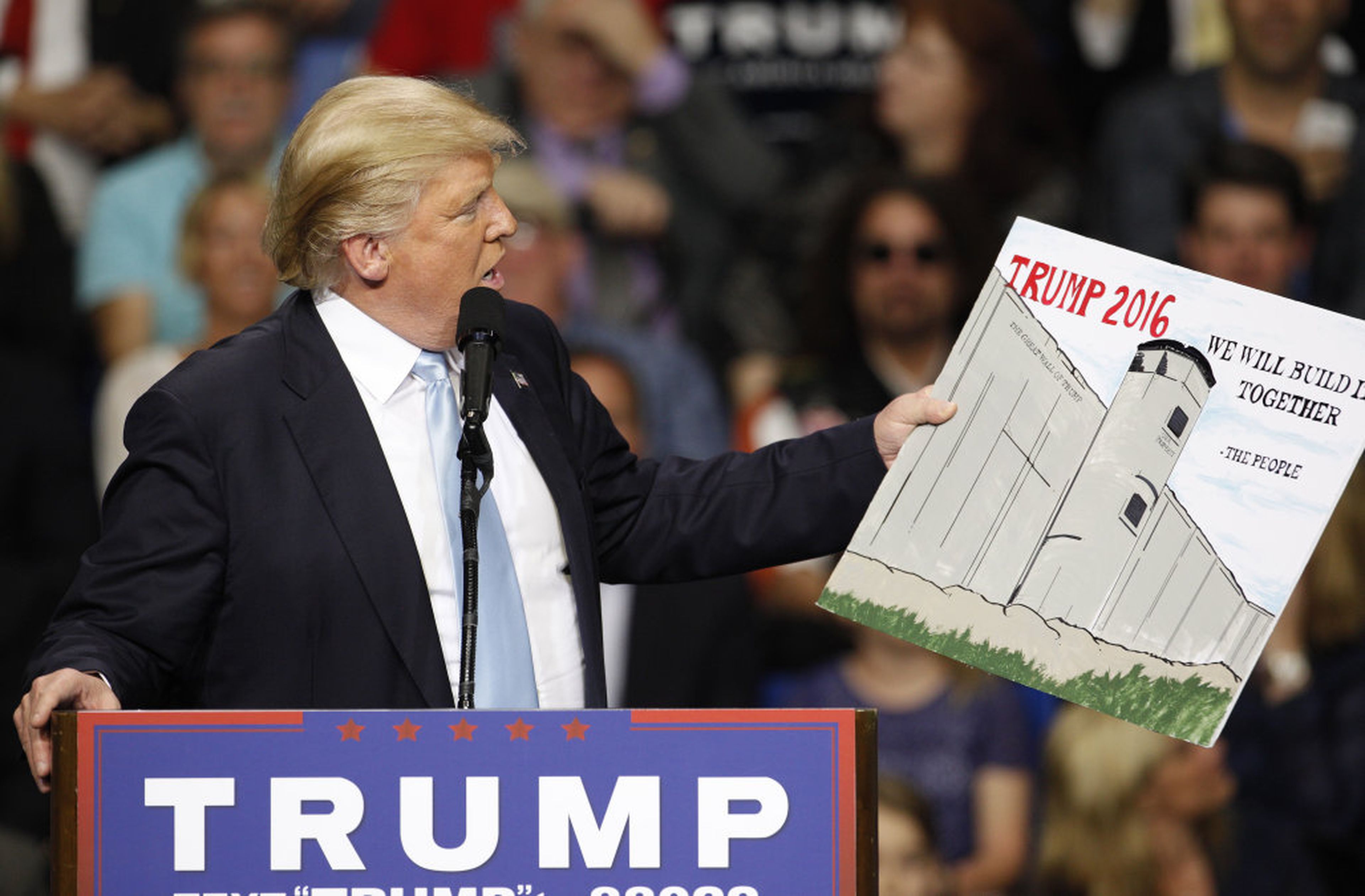 Trump muestra un cartel con el muro con México en la campaña de 2016.