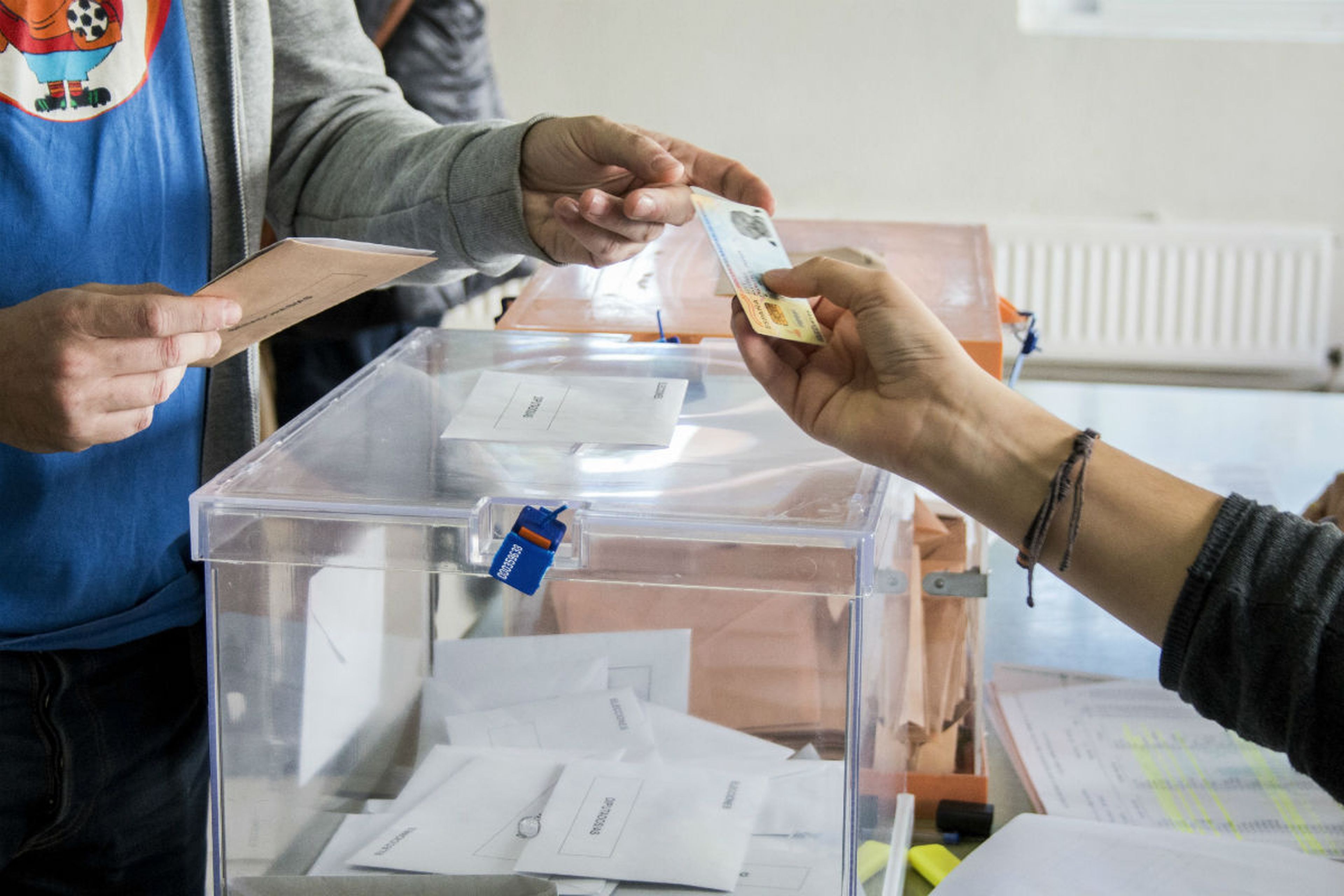 Un votante entrega su DNI en una mesa electoral.