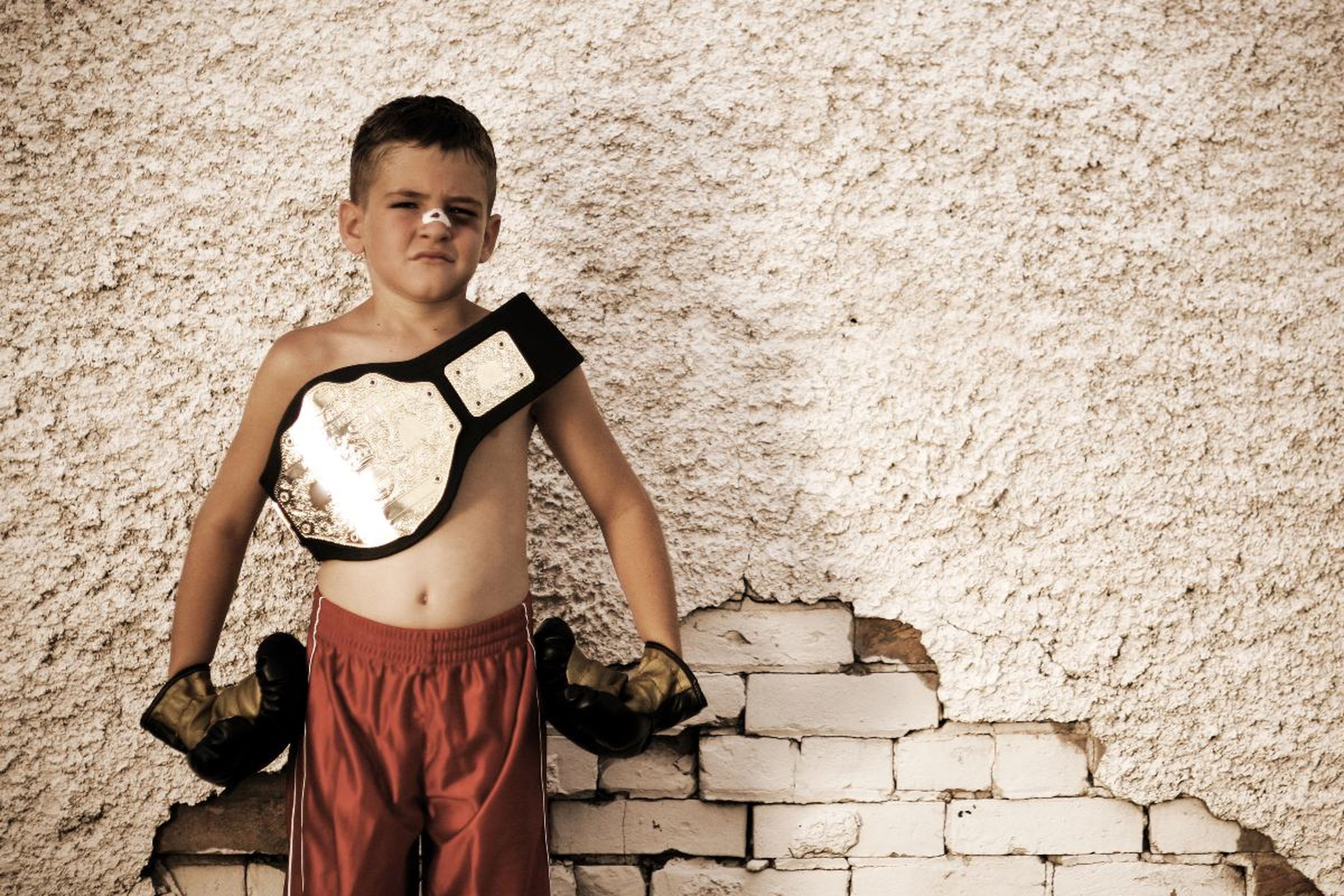 Un boxeador de categoría infantil con su cinturón de campeón