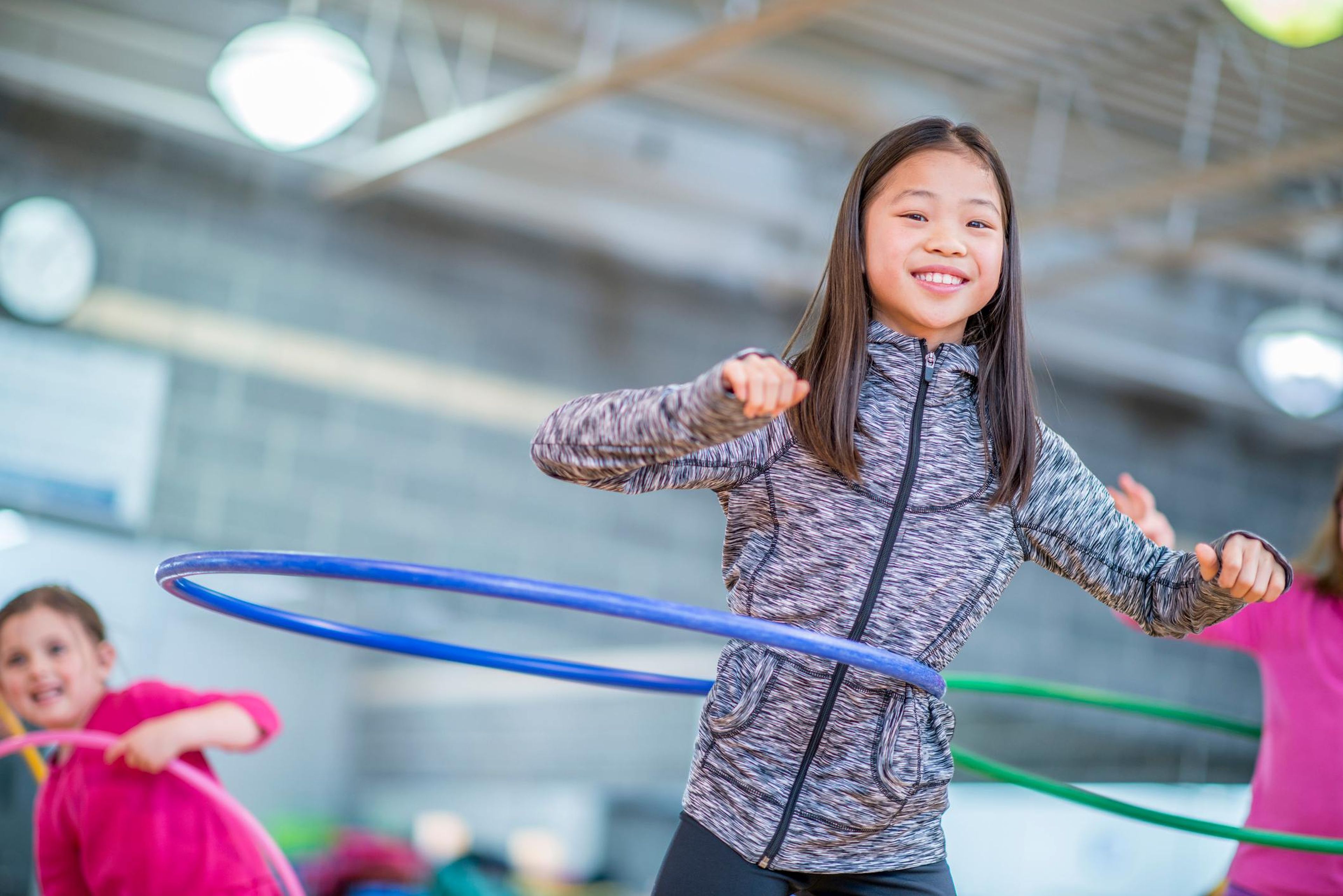 Una niña juega con un aro Hula Hoop