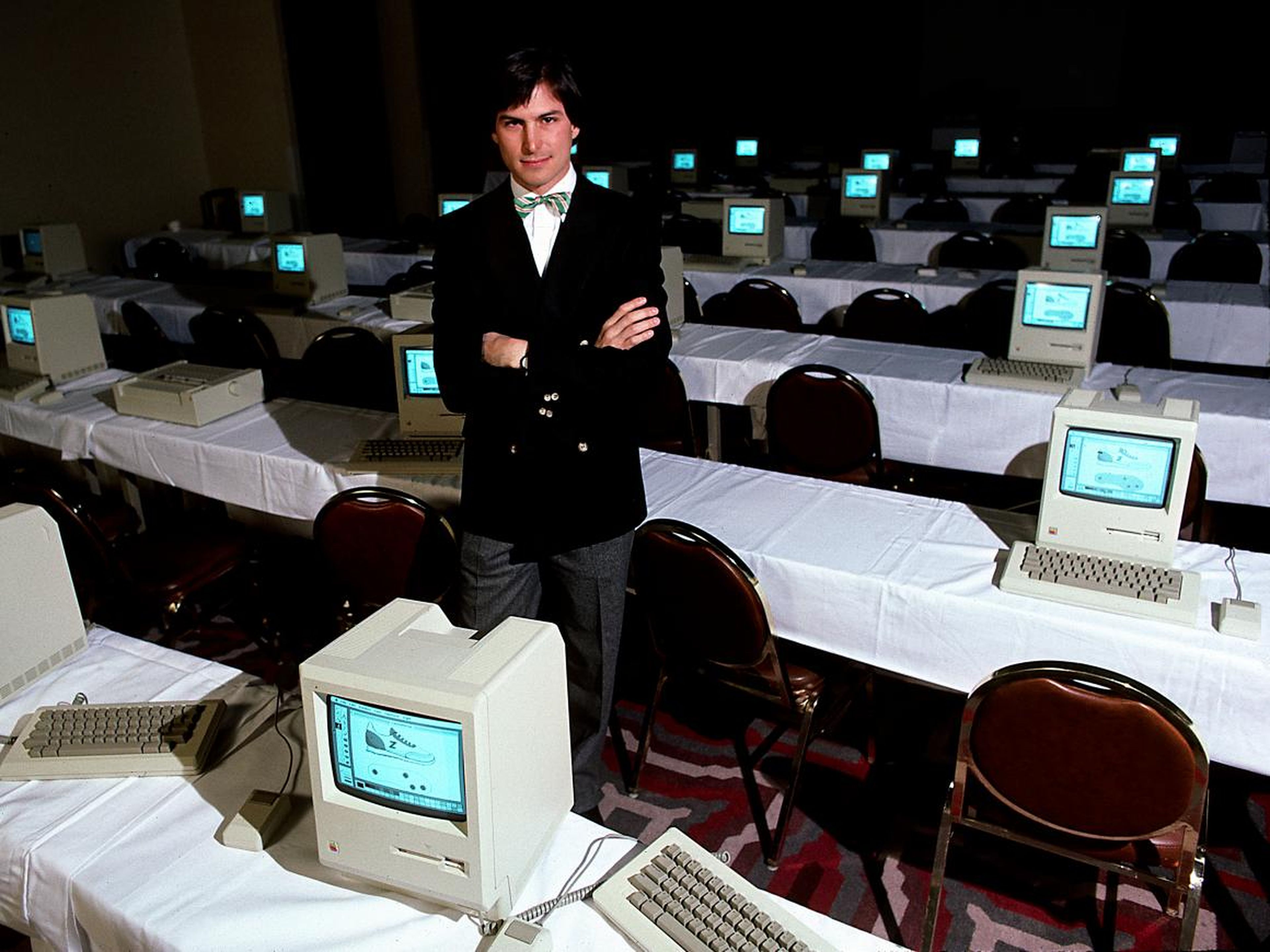 El CEO de Apple Steve Jobs rodeado de ordenadores Macintosh.