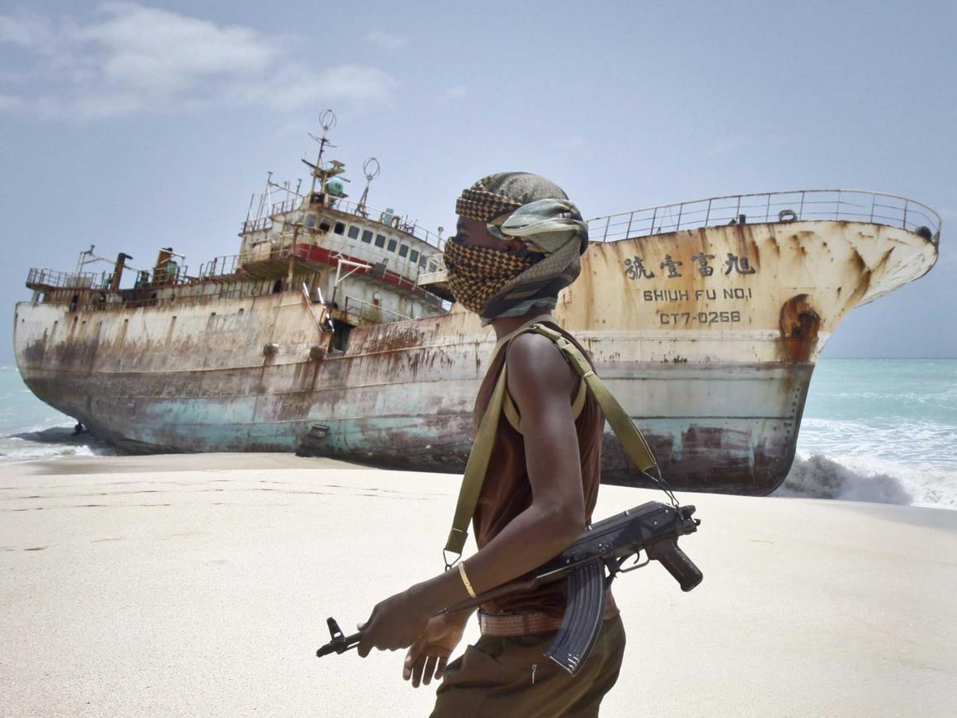 El pirata somalí enmascarado Abdi Ali pasa frente a un barco pesquero taiwanés que llegó a la costa el 23 de septiembre de 2012, luego de que los piratas recibieran el importe del rescate y liberaran a la tripulación.