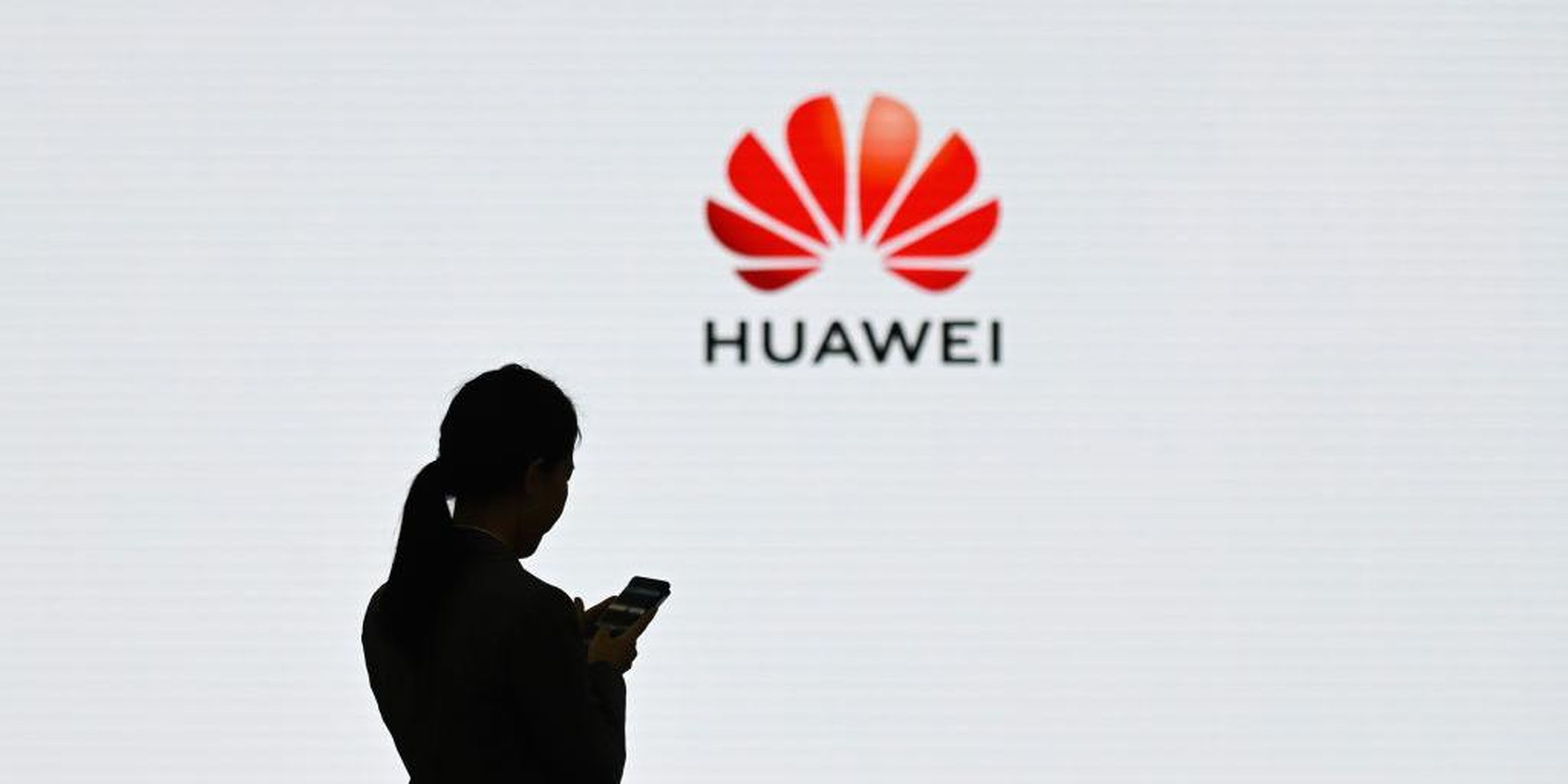 A staff member of Huawei uses her mobile phone at a conference in Shenzhen, in March 2019. The telecom company has at the center of global security concerns.