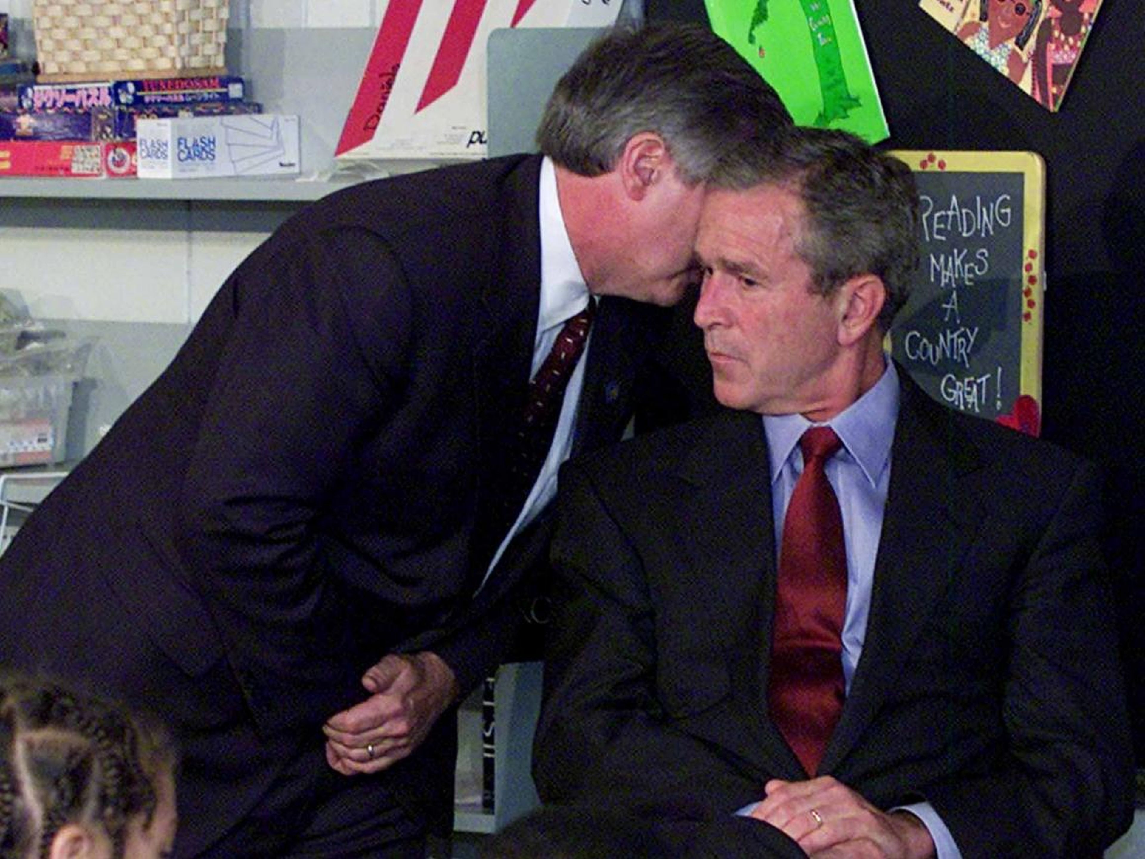 El jefe de personal del presidente Bush, Andy Card, susurra al oído del presidente durante una visita a la Escuela Primaria Emma E. Booker en Sarasota, Florida, el 11 de septiembre de 2001