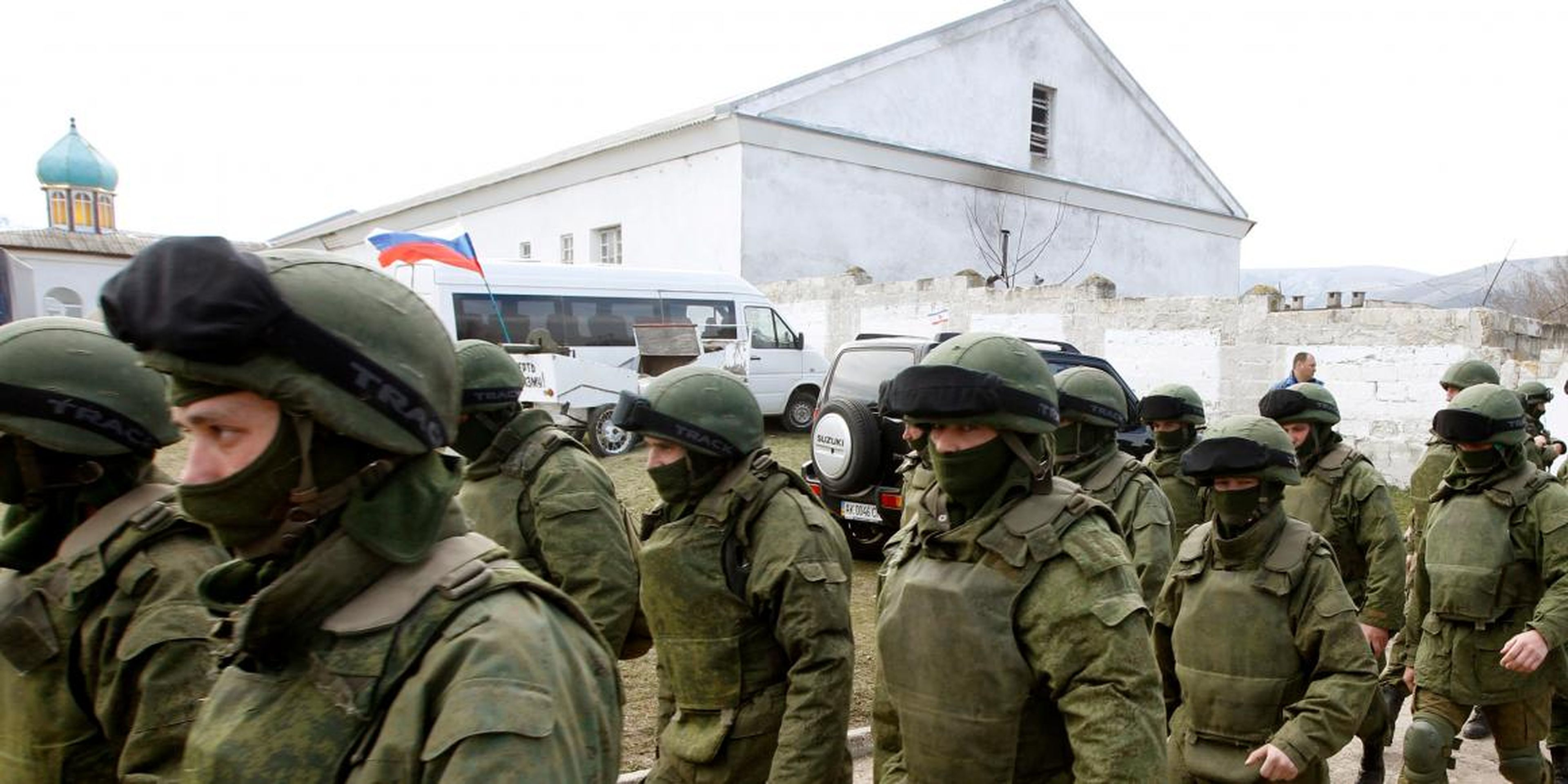 Armed men, believed to be Russian servicemen, walk outside a Ukrainian military base in Perevalnoye, near the Crimean city of Simferopol, March 14, 2014.