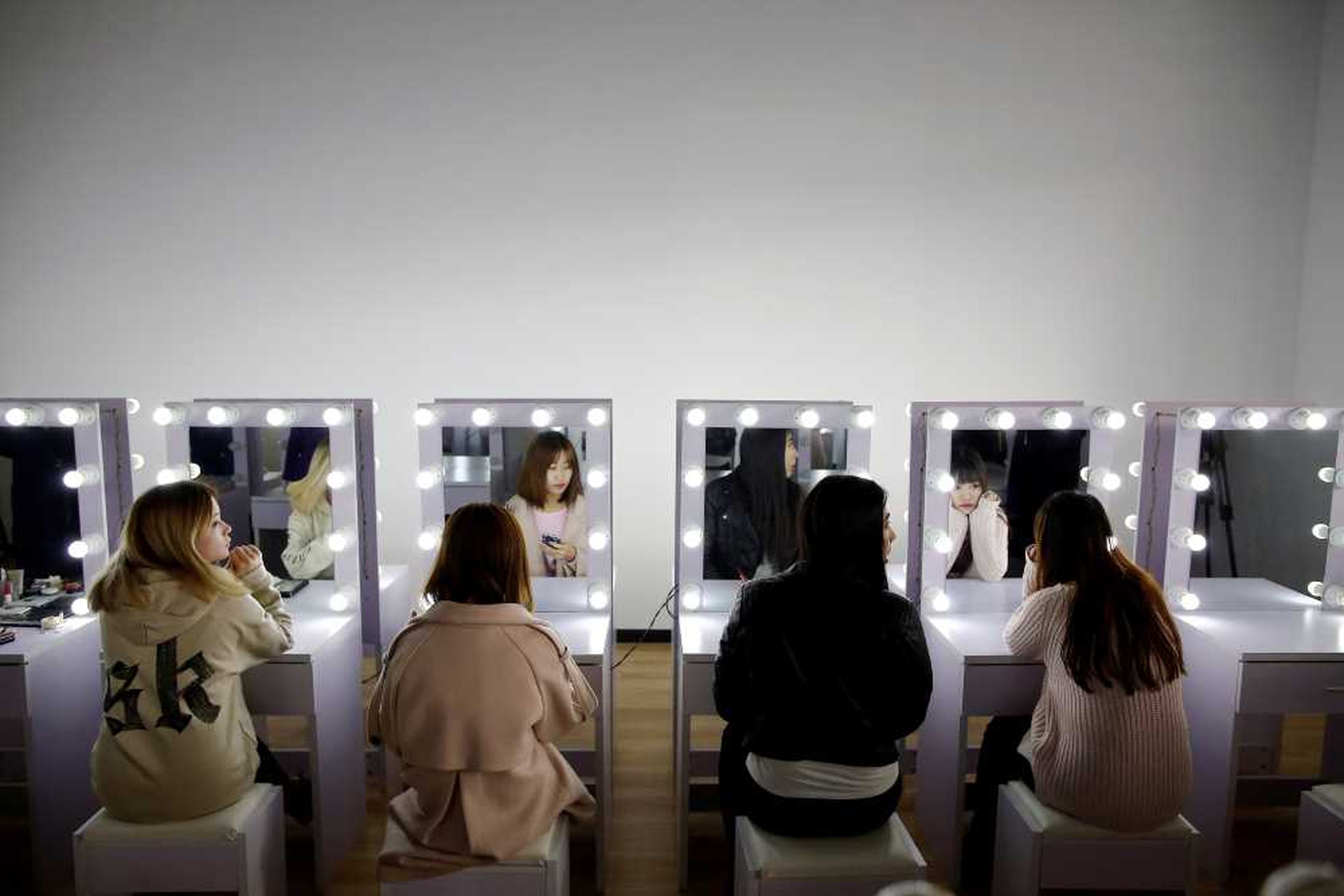 Chicas asisten a una sesión de formación de maquillaje en la agencia de talento de streaming en directo Three Minute TV en Pekín.