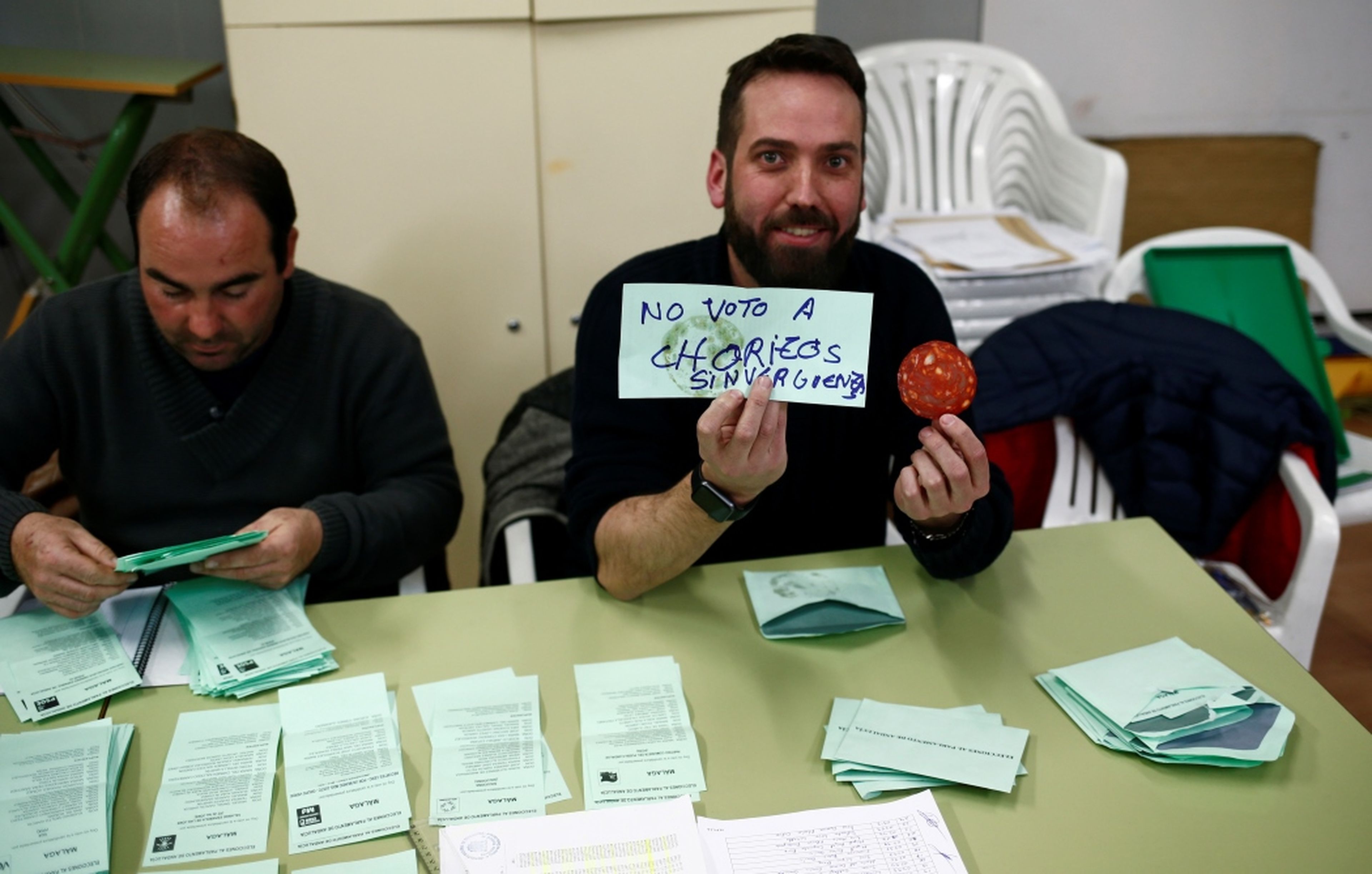 Un miembro de una mesa electoral enseña el contenido de un sobre en Ronda, Málaga.