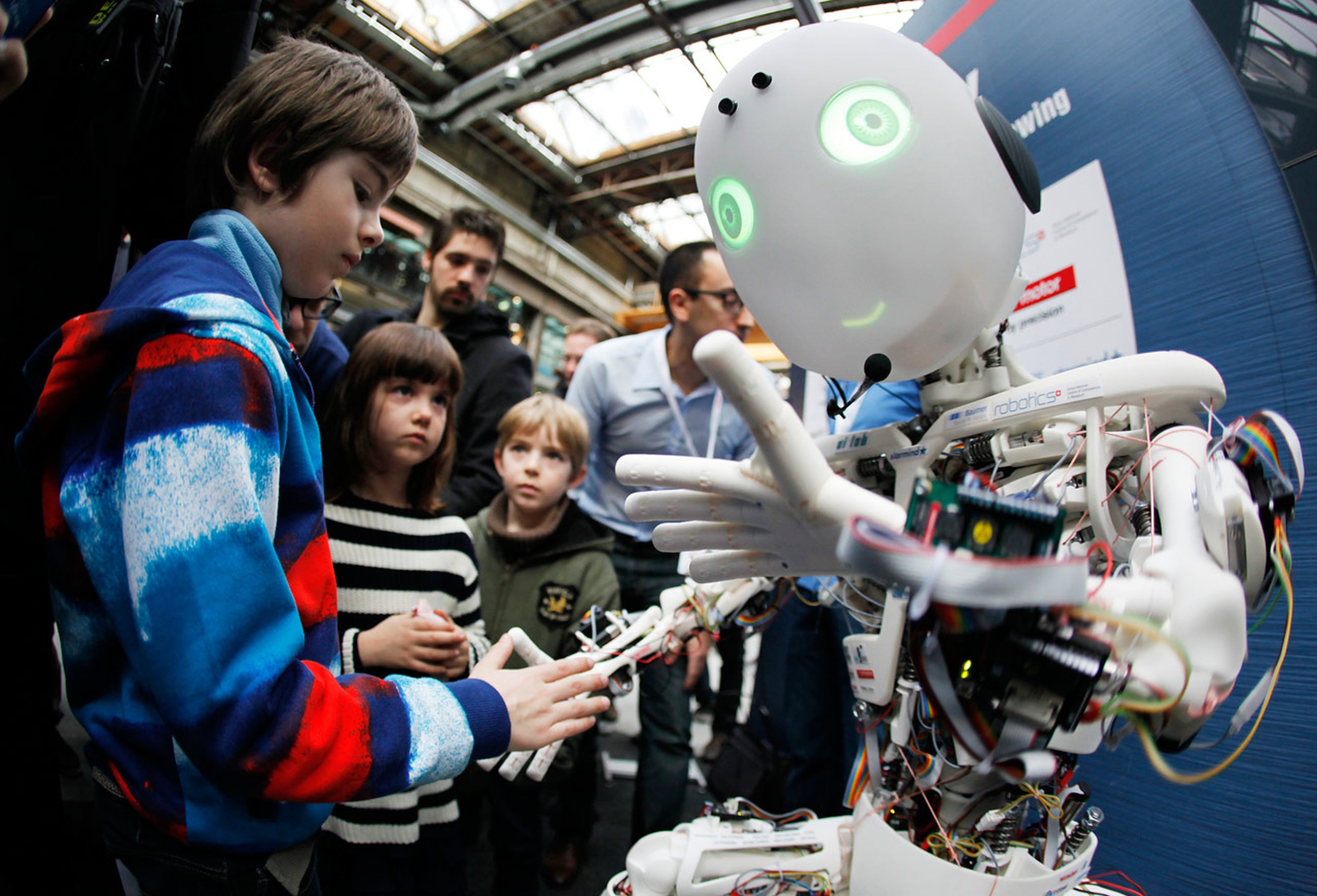 Un grupo de niños juega con un robot de Inteligencia Artificial