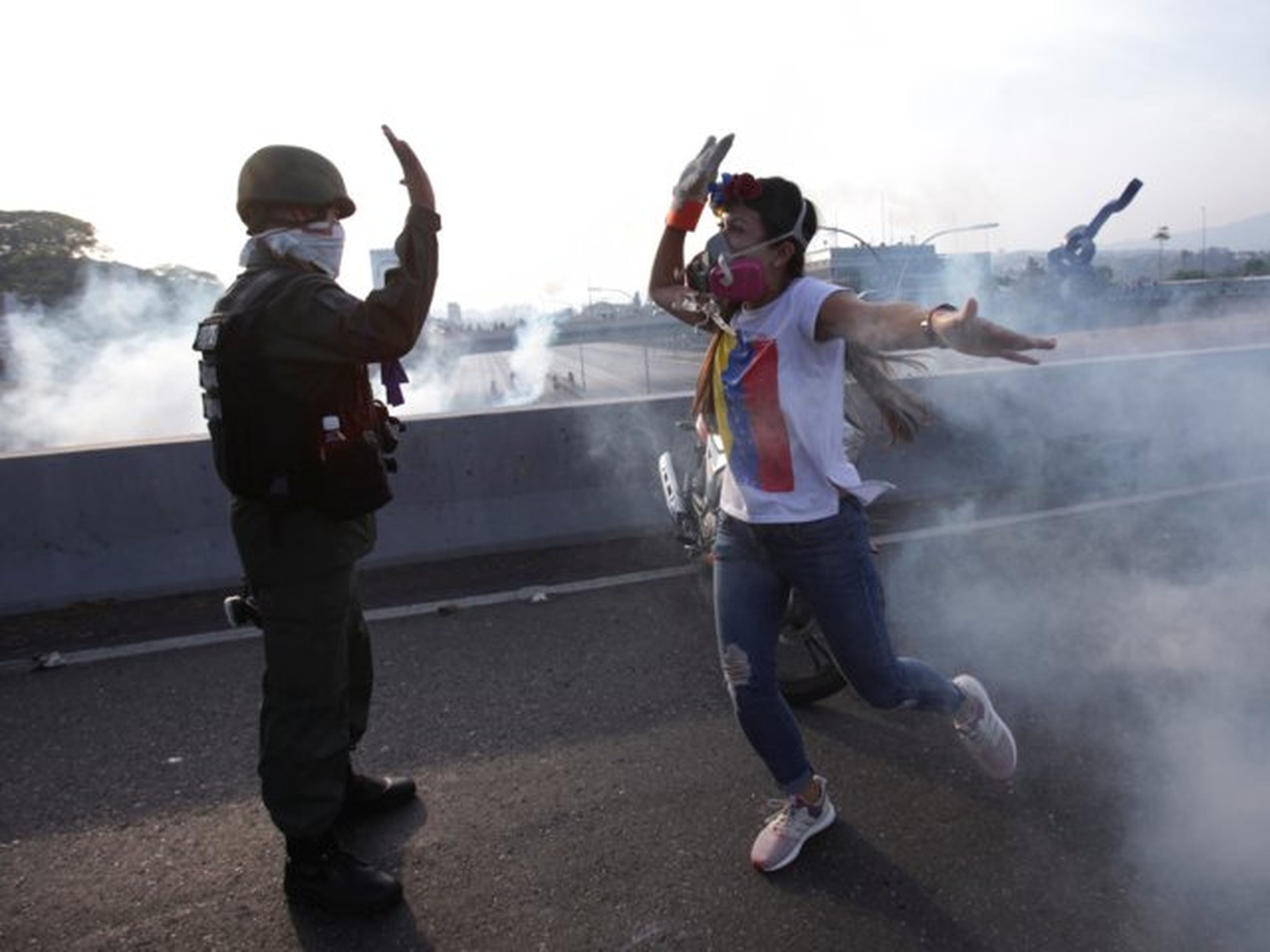 Una manifestante opositora saluda a un soldado fiel a Guaidó ante la base de La Carlota, Caracas