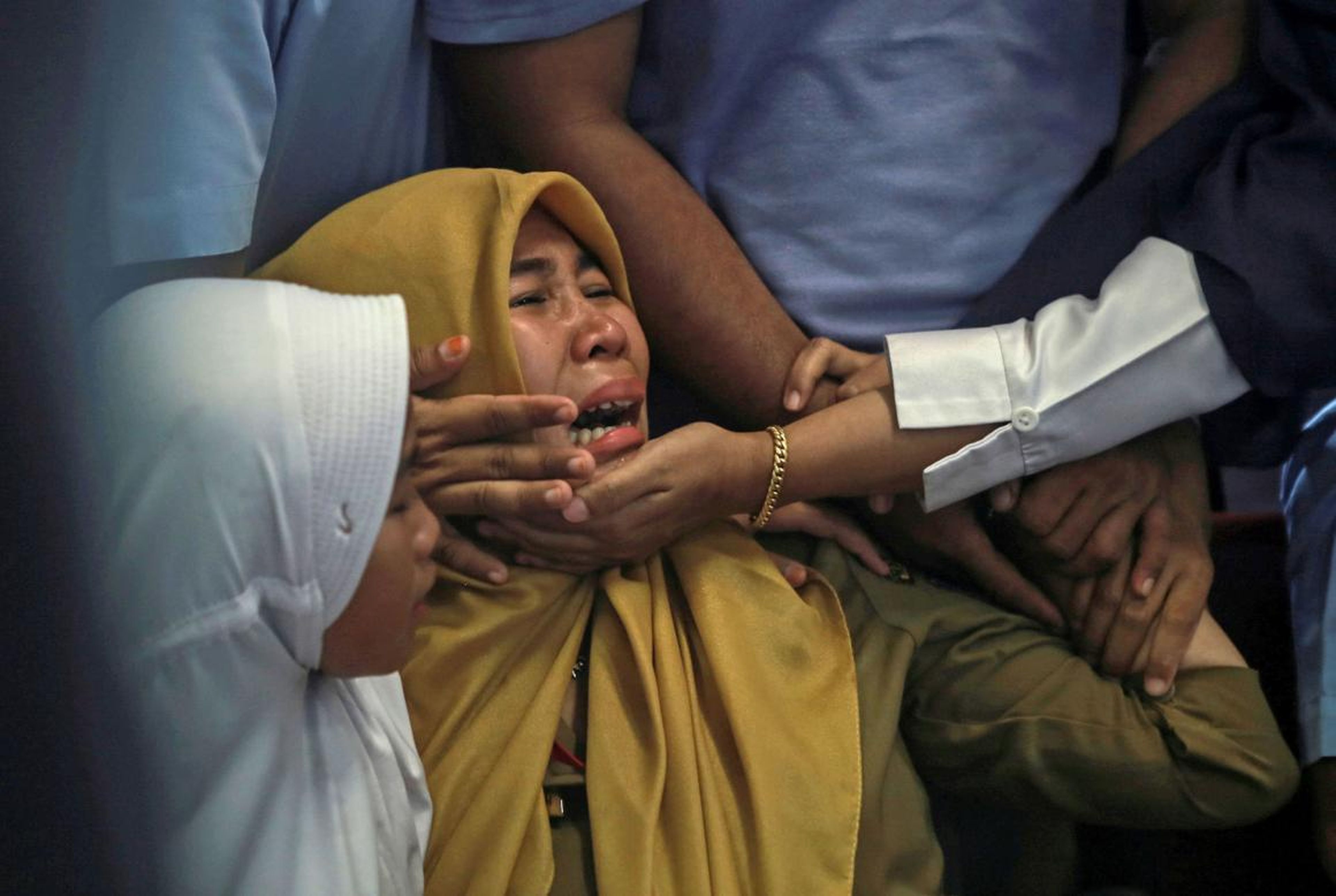 Familiares de pasajeros en el vuelo accidentado de Lion Air lloran en el aeropuerto de Amati, Pangkal Pinang, isla de Belitung, Indonesia.