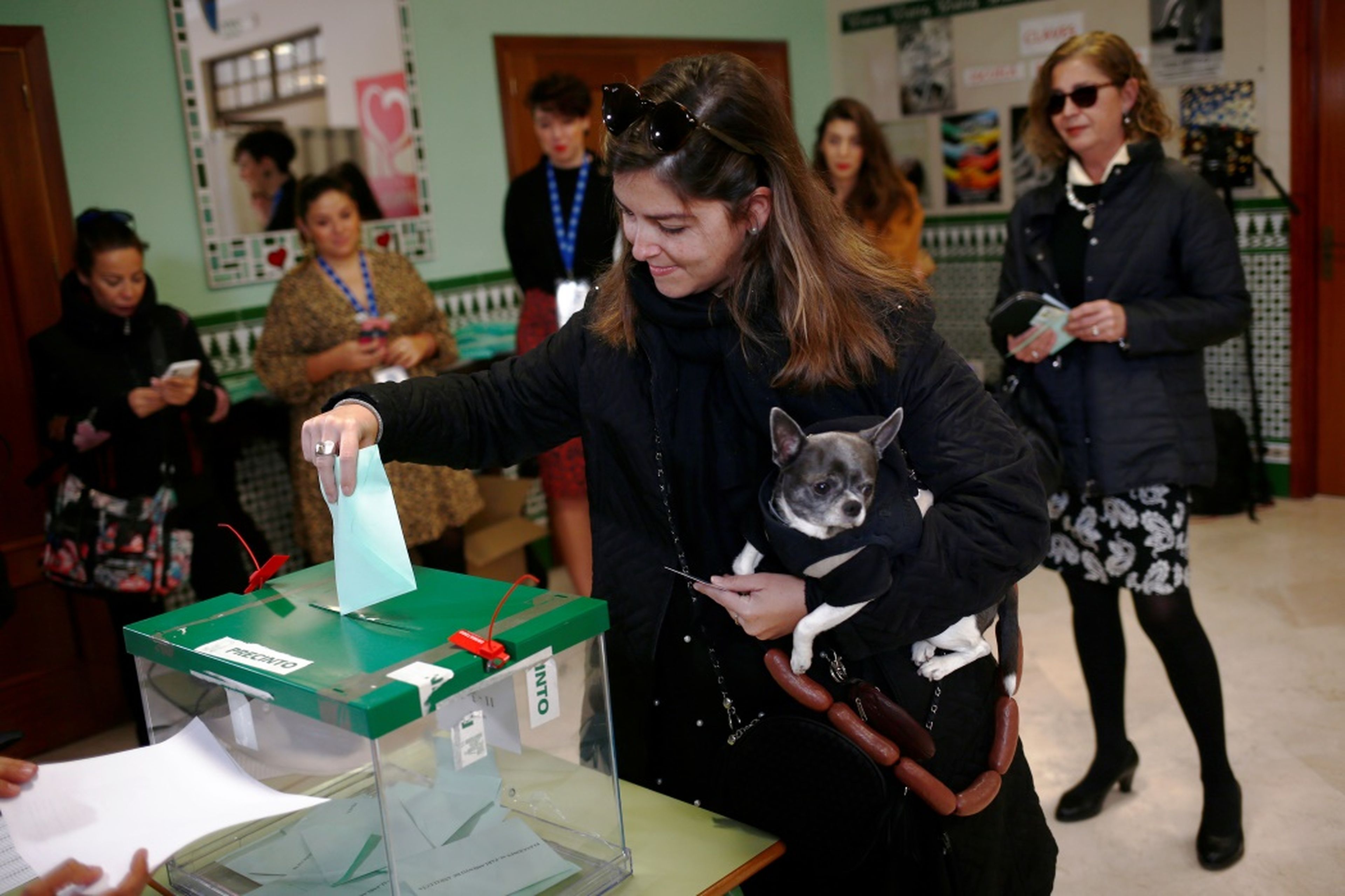 Una chica vota con su perro en las elecciones andaluzas de 2018, en Málaga.