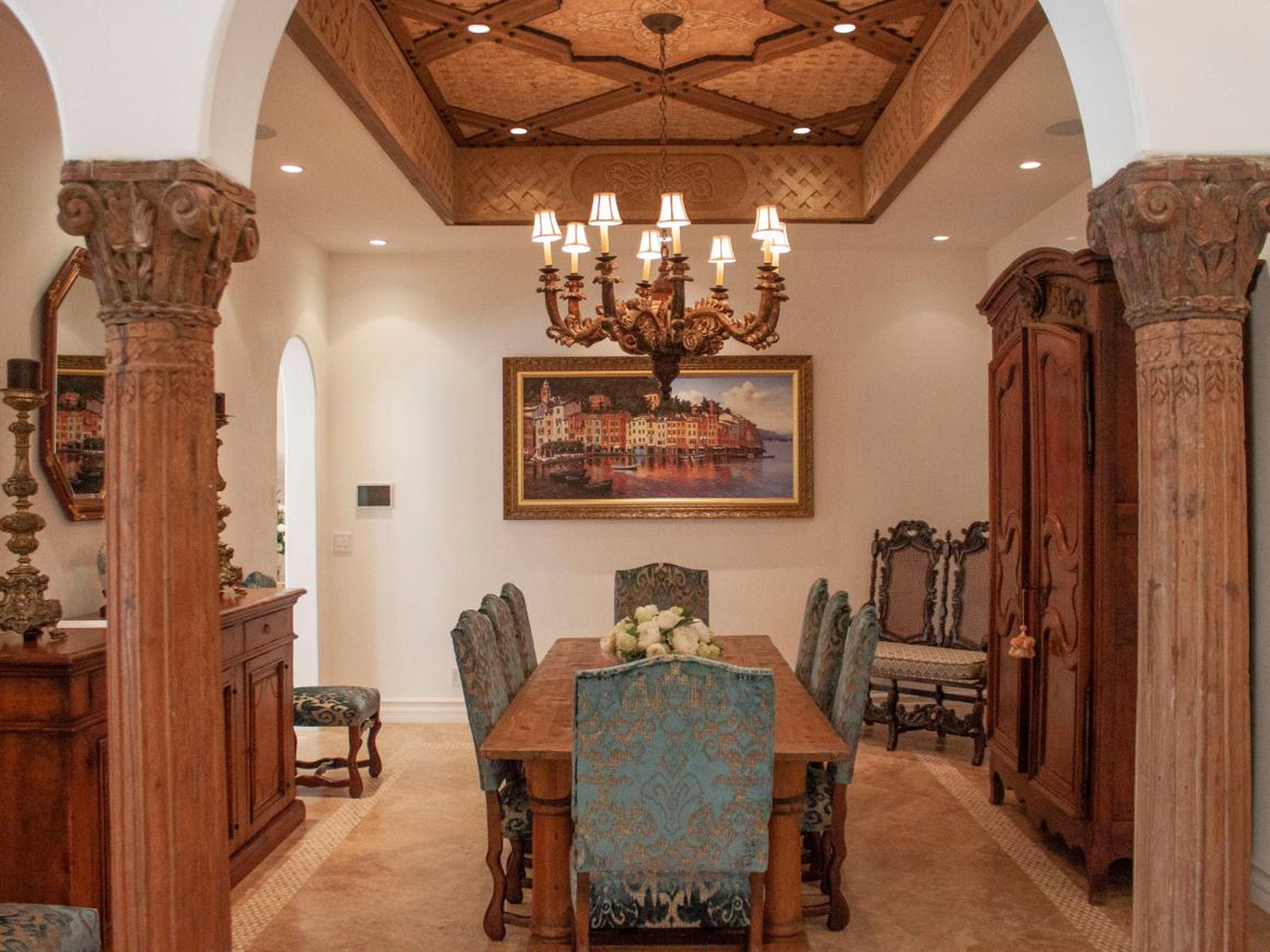The formal dining room includes intricate wood detailing and a painting of Italy.