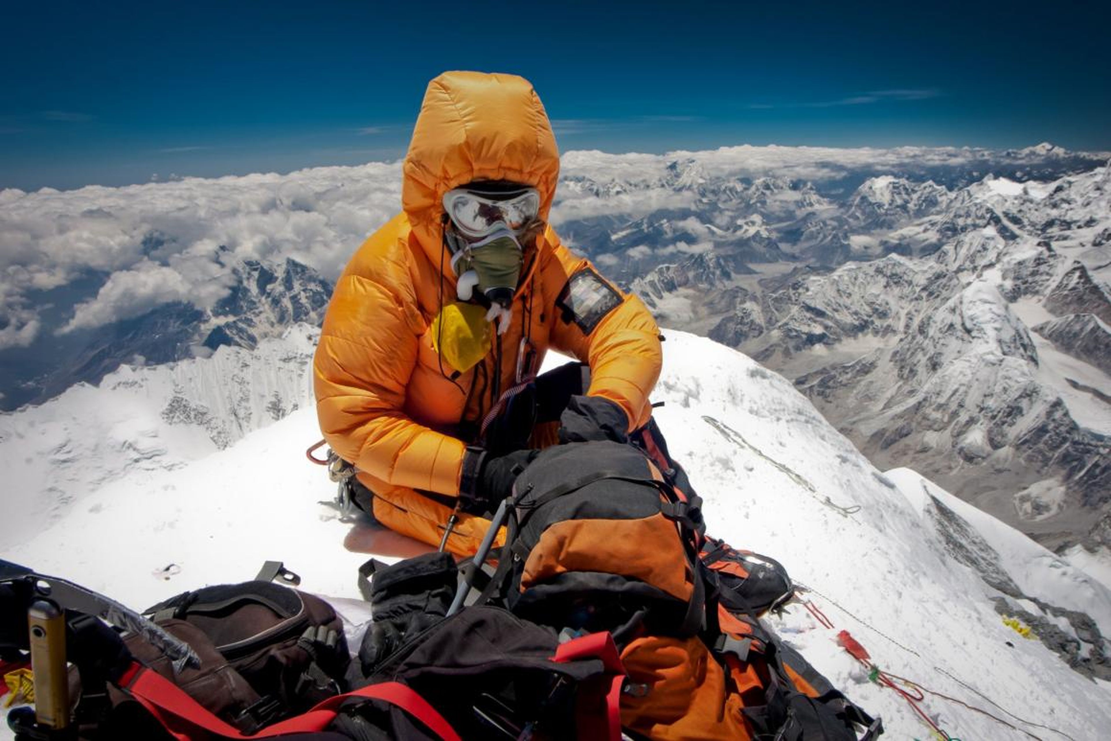 Un escalador descansando en la cima del Everest, la montaña más alta del mundo que está entre el Tibet y Nepal