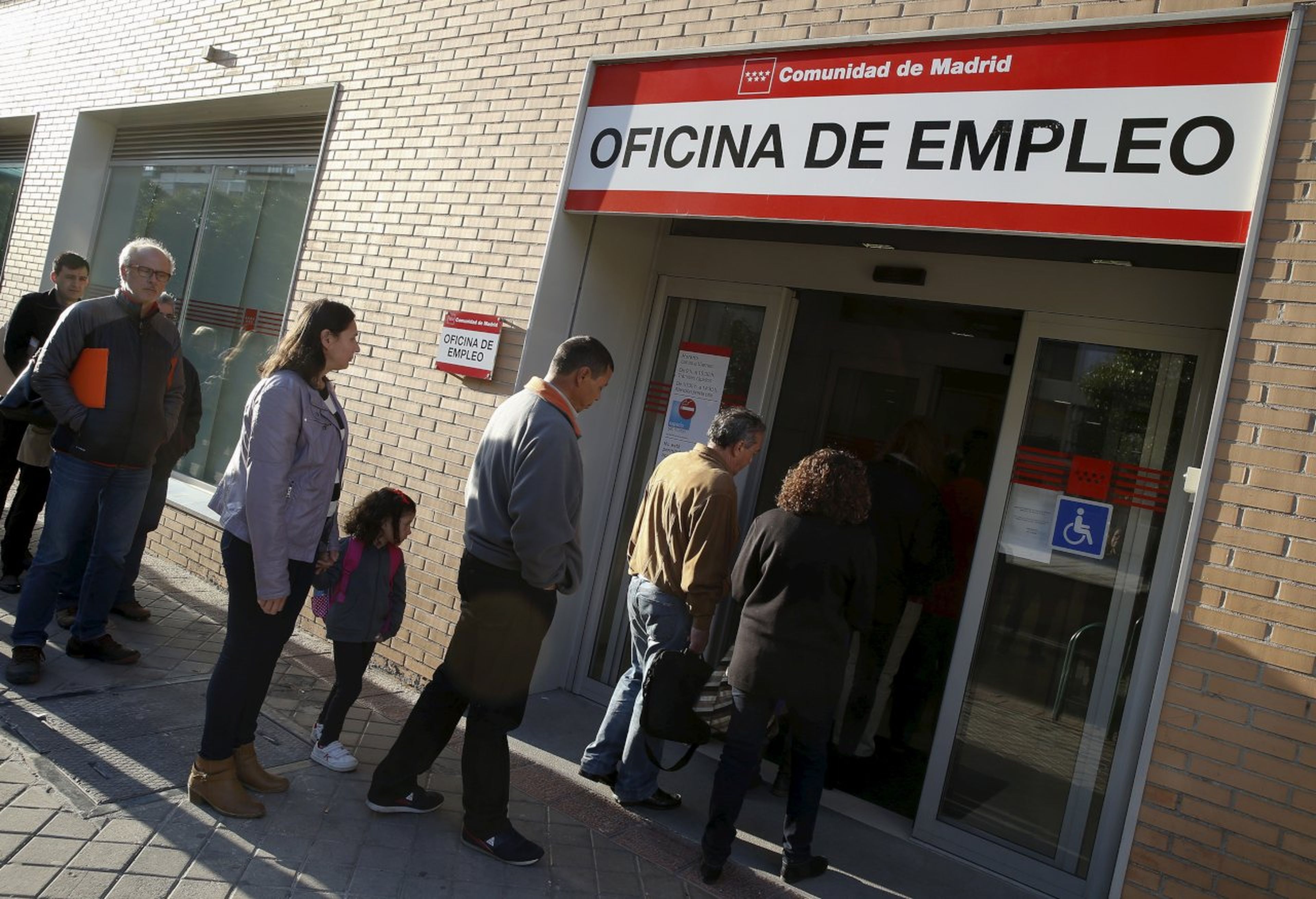 Un grupo de desempleados hace cola ante una oficina de empleo de Madrid