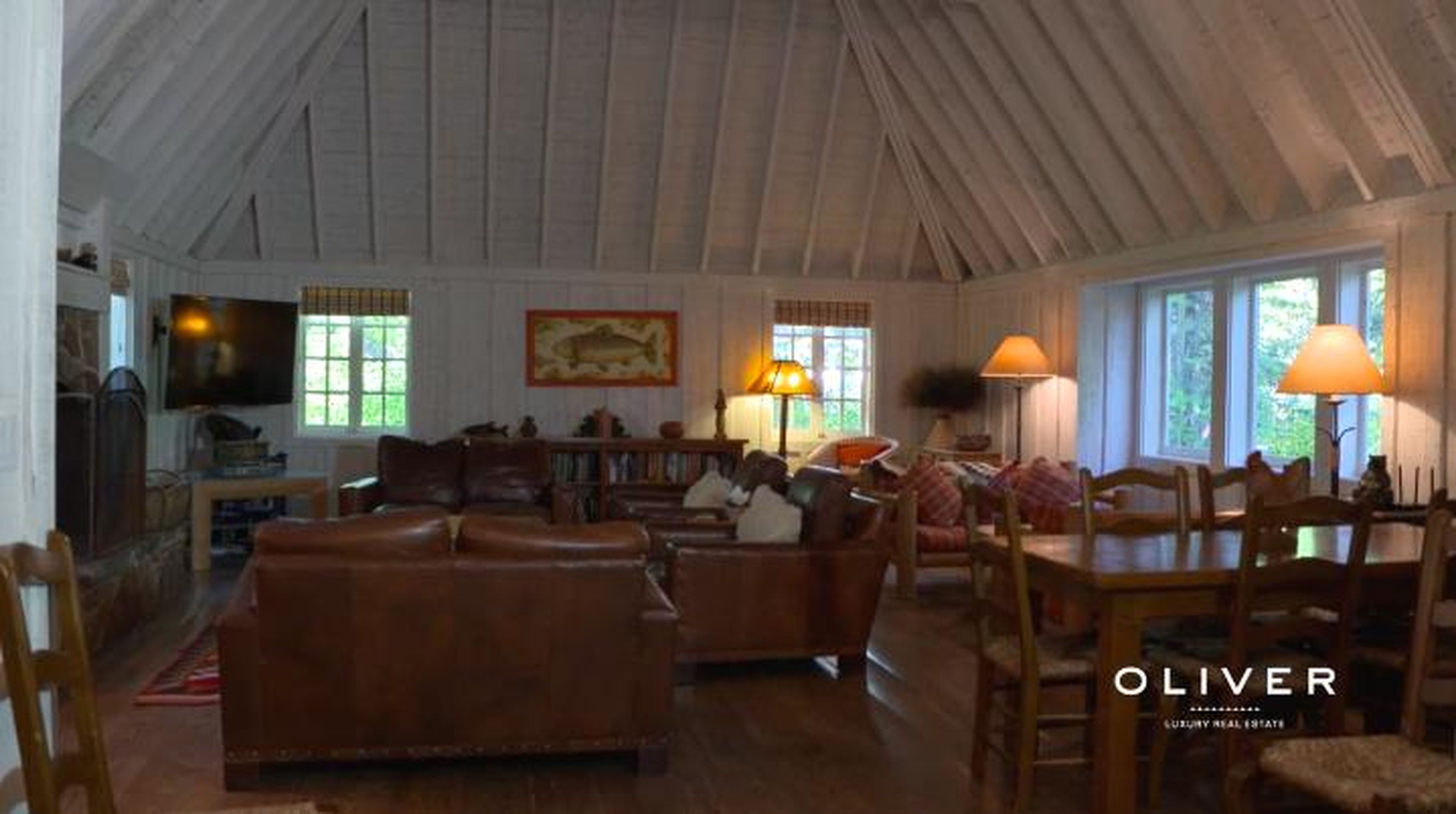The main section of the house has a large living room with high ceilings and a wood-burning fireplace — a nice place to lounge after a long day at the lake or in the winter, after skiing on the nearby slopes.
