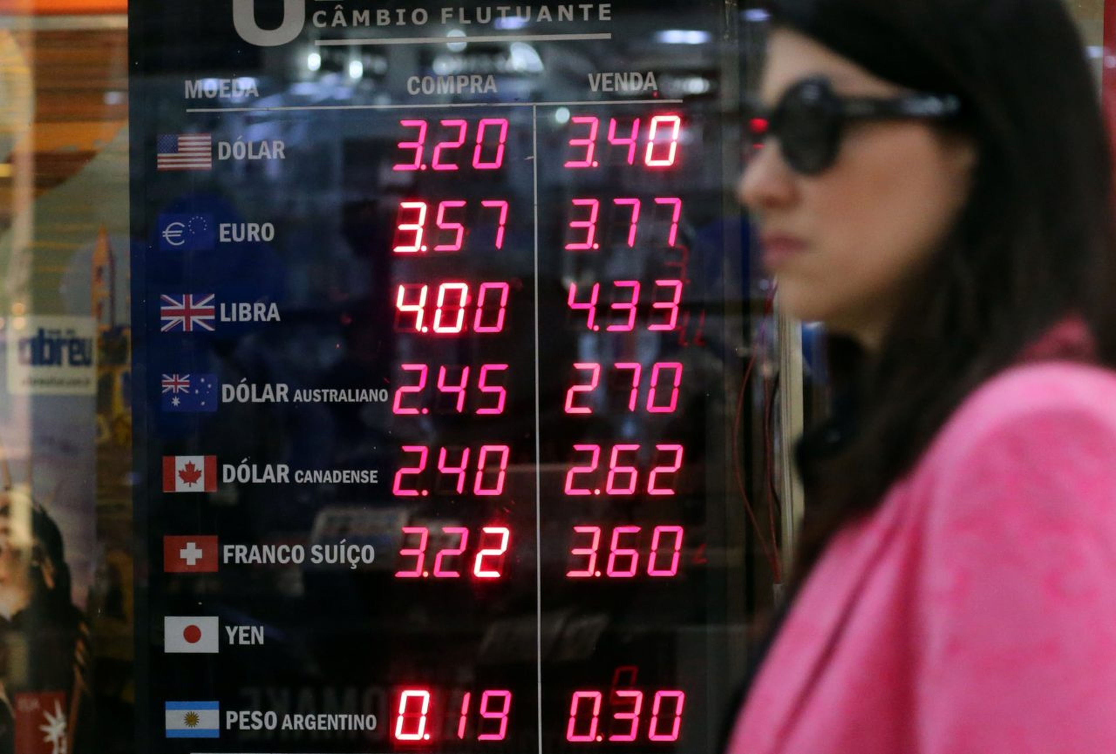 Una mujer pasea ante una oficina de cambio en Brasil
