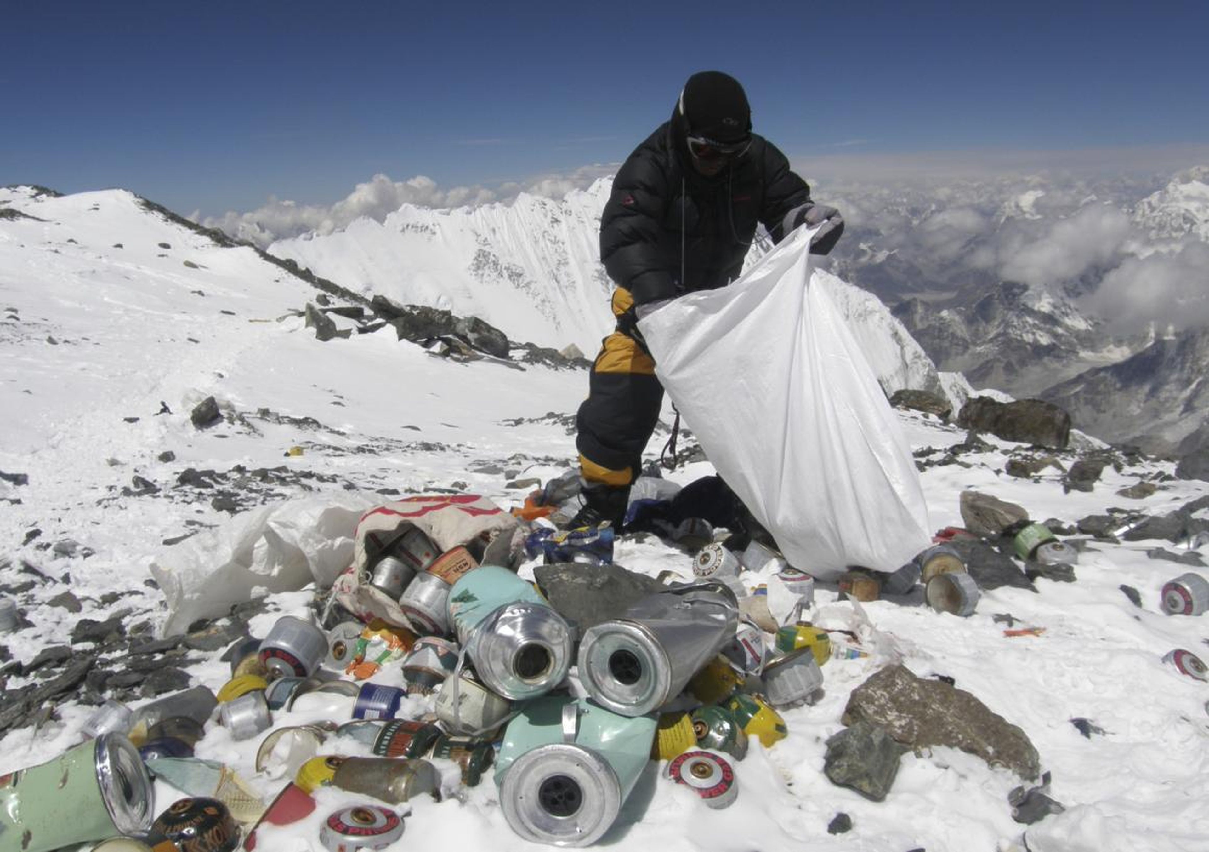 A Nepalese Sherpa collecting garbage, left by climbers, at an altitude of 8,000 meters, in May 2010.