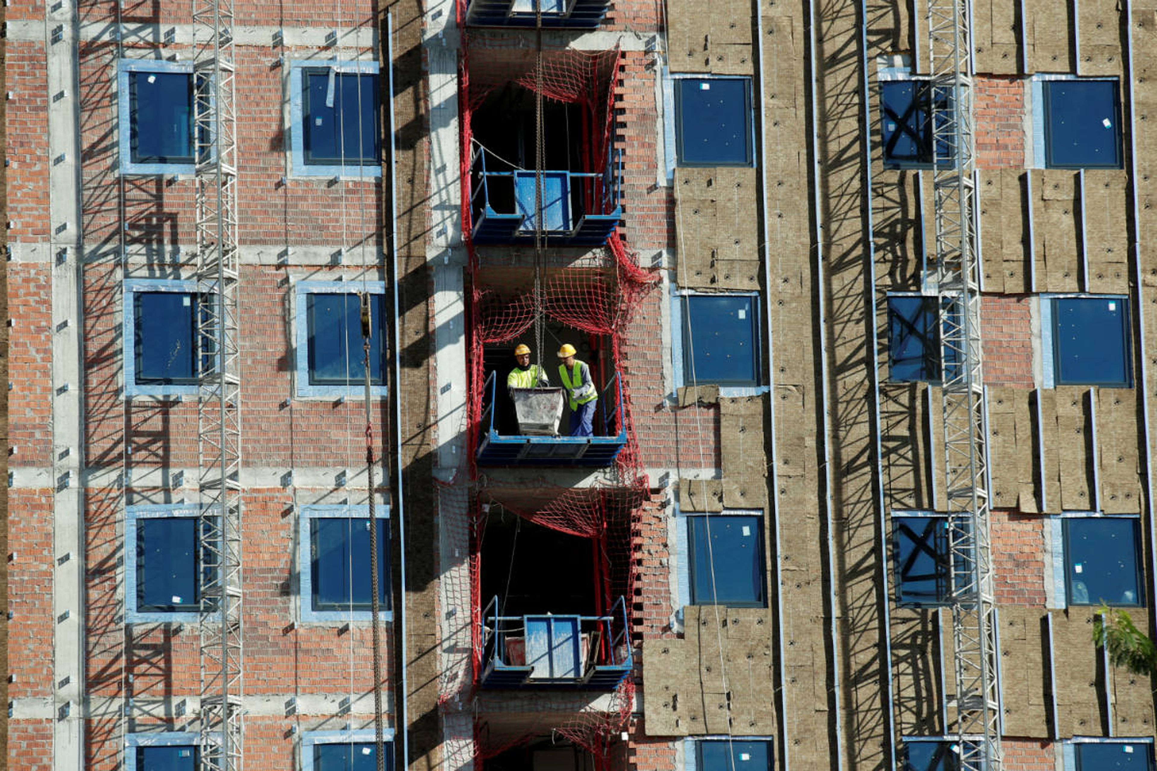 Unos obreros en la construcción de un bloque de pisos en Barcelona.