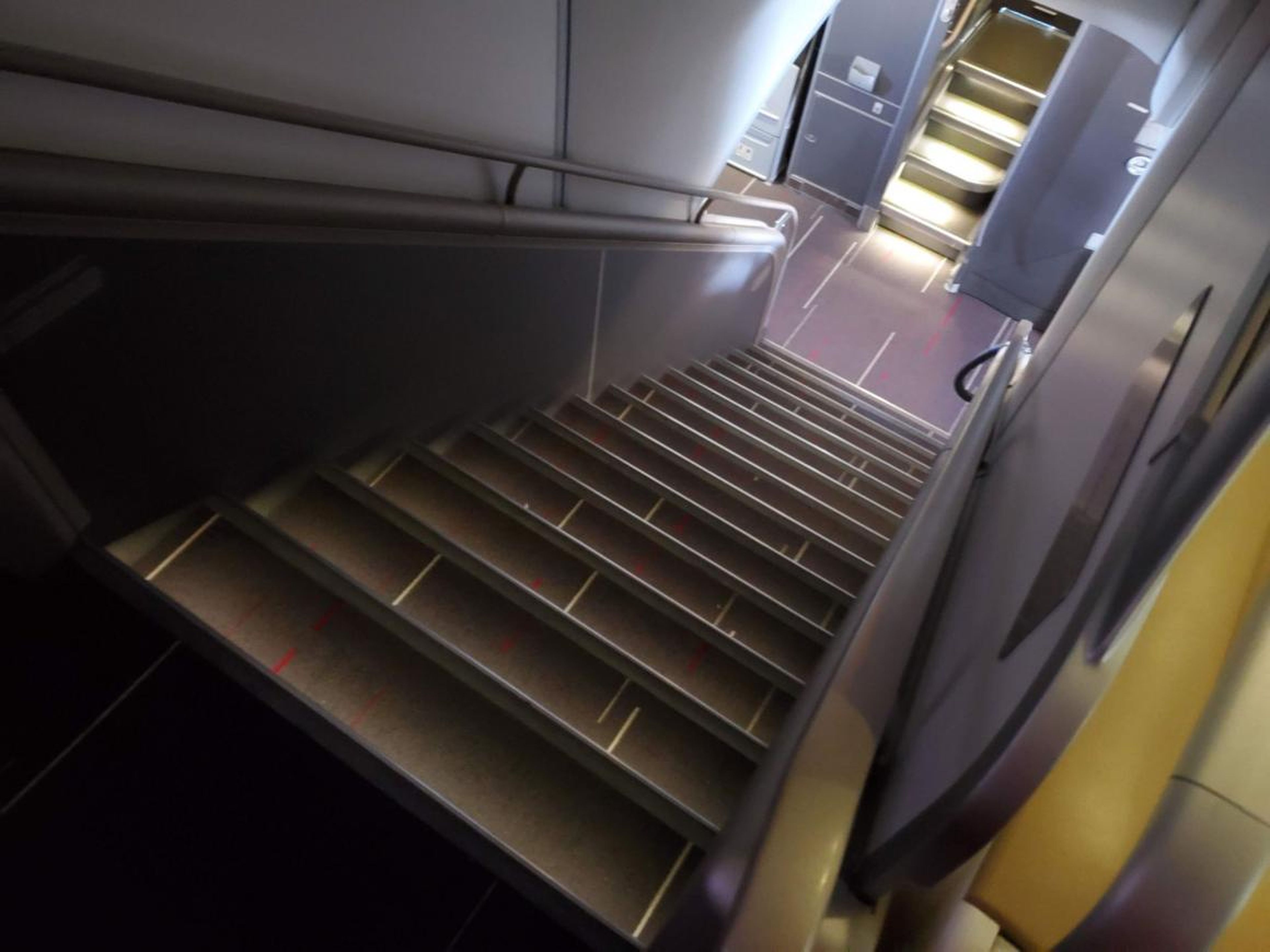 Bajando esas escaleras, al frente del avión, están las nueve suites de primera clase.