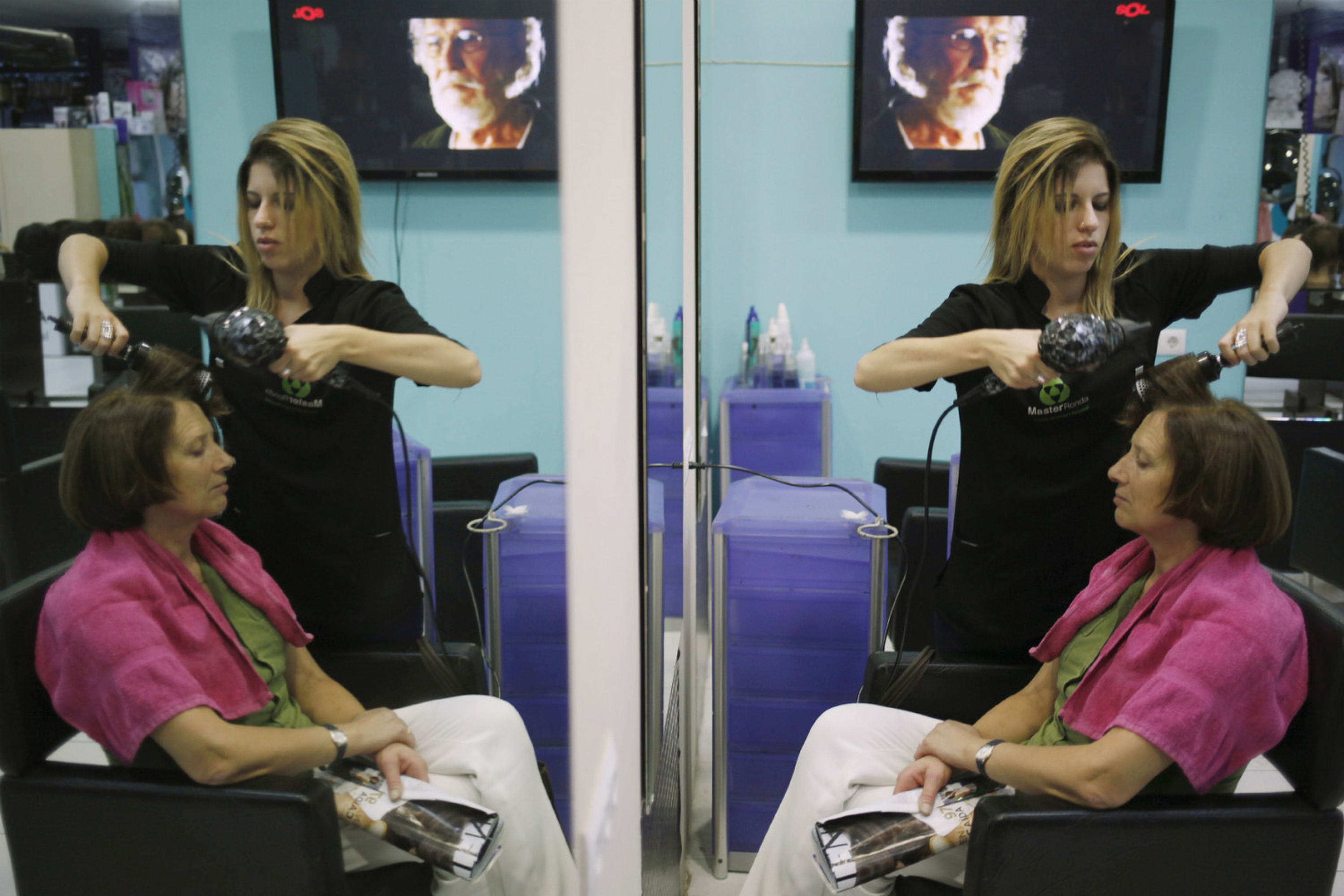 Una peluquera atiende a una clienta en un salón de belleza en Ronda (Málaga).