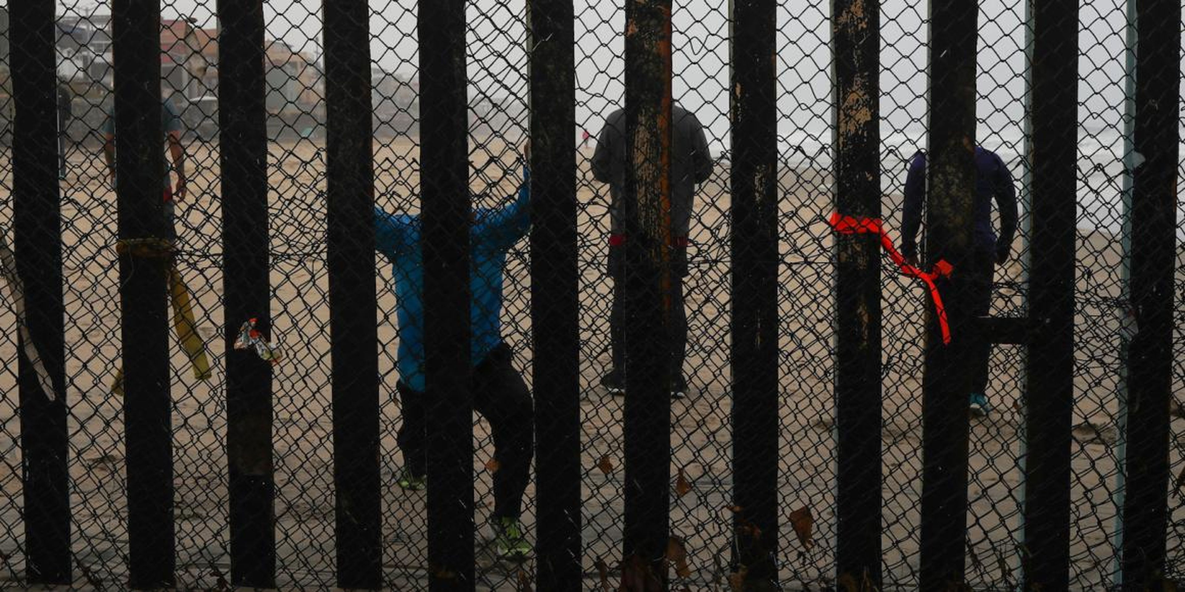 People on the Mexico side of the border wall near San Diego in June 2018.