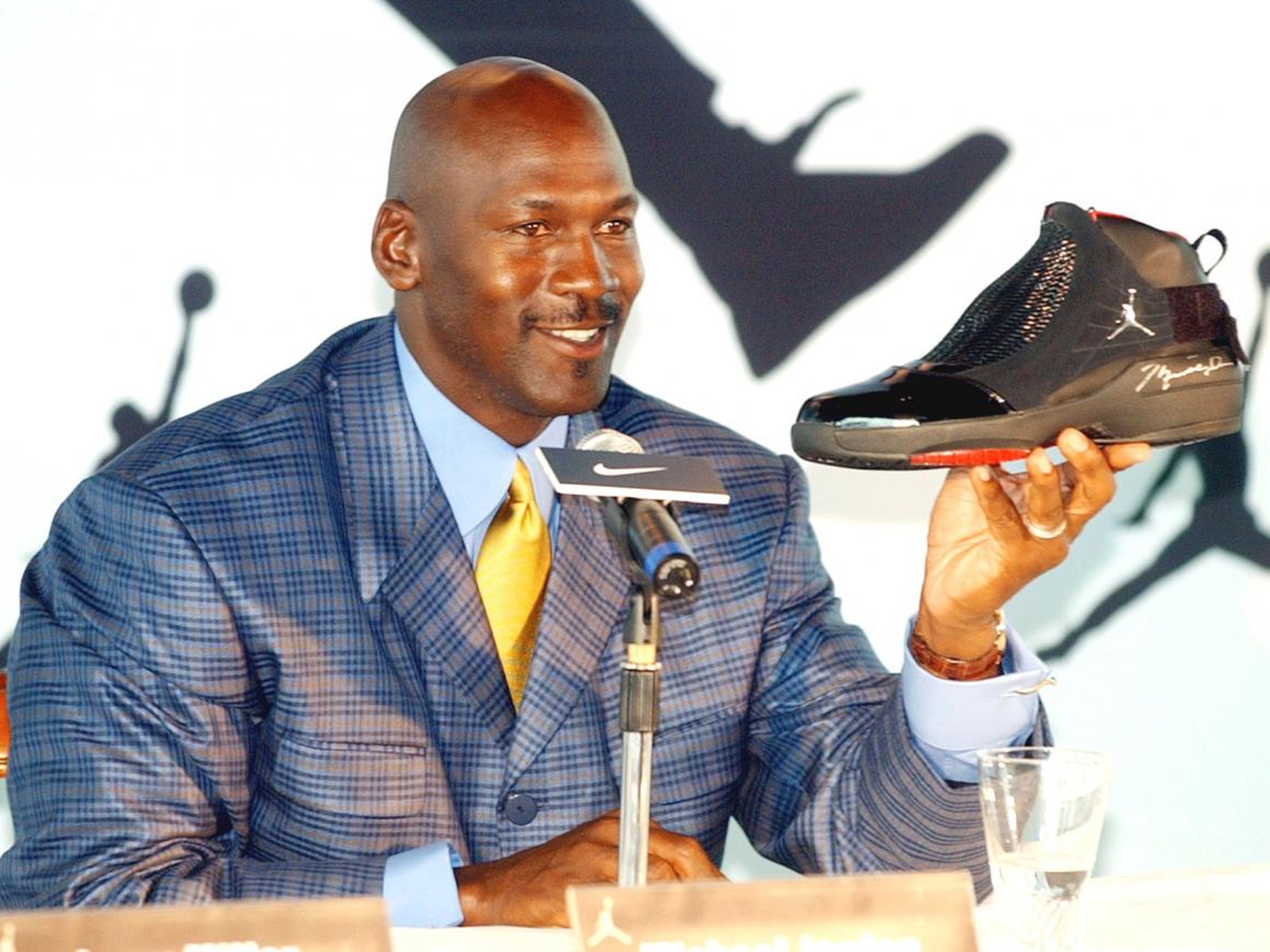 La leyenda de la NBA Michael Jordan sostiene un zapato AJ19 autografiado, el último diseño de la línea de zapatos Air Jordan, en una conferencia de prensa en Hong Kong.