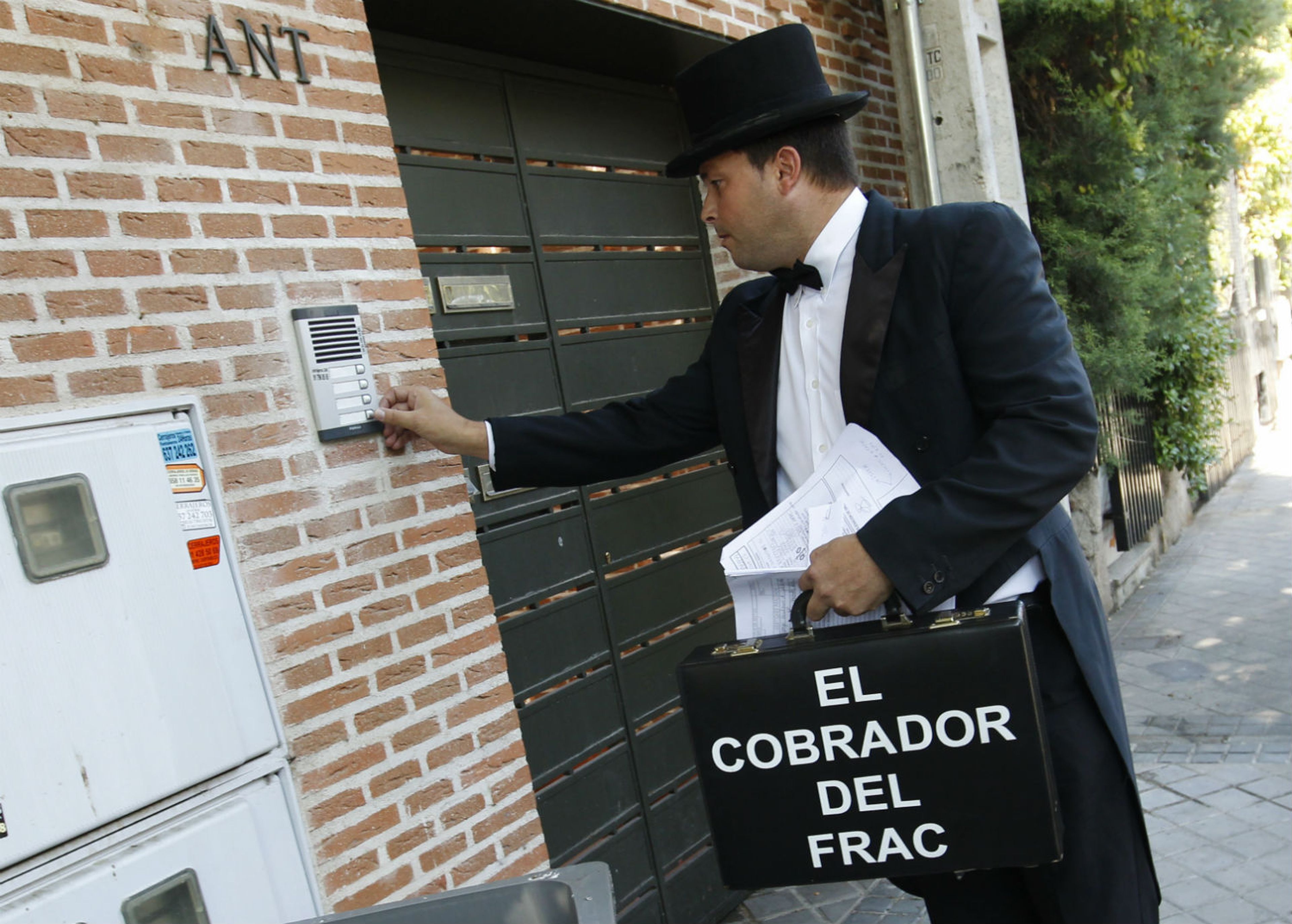 Un trabajador de la empresa El Cobrador del Frac toca el timbre de una vivienda en Pozuelo de Alarcón (Madrid).