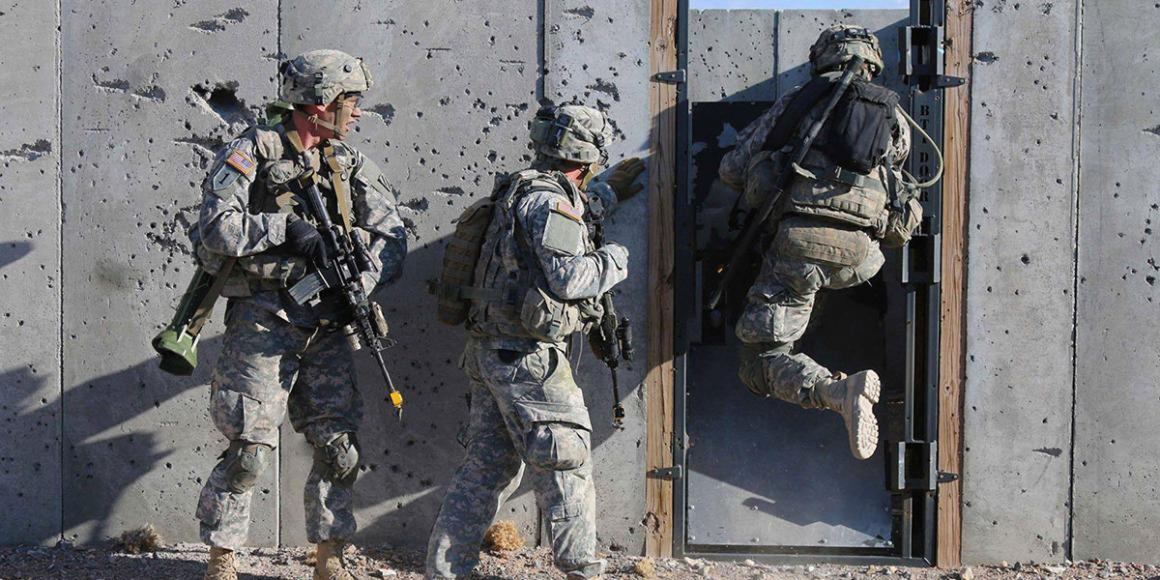 US soldiers conduct breaching operations in a mock-urban environment.