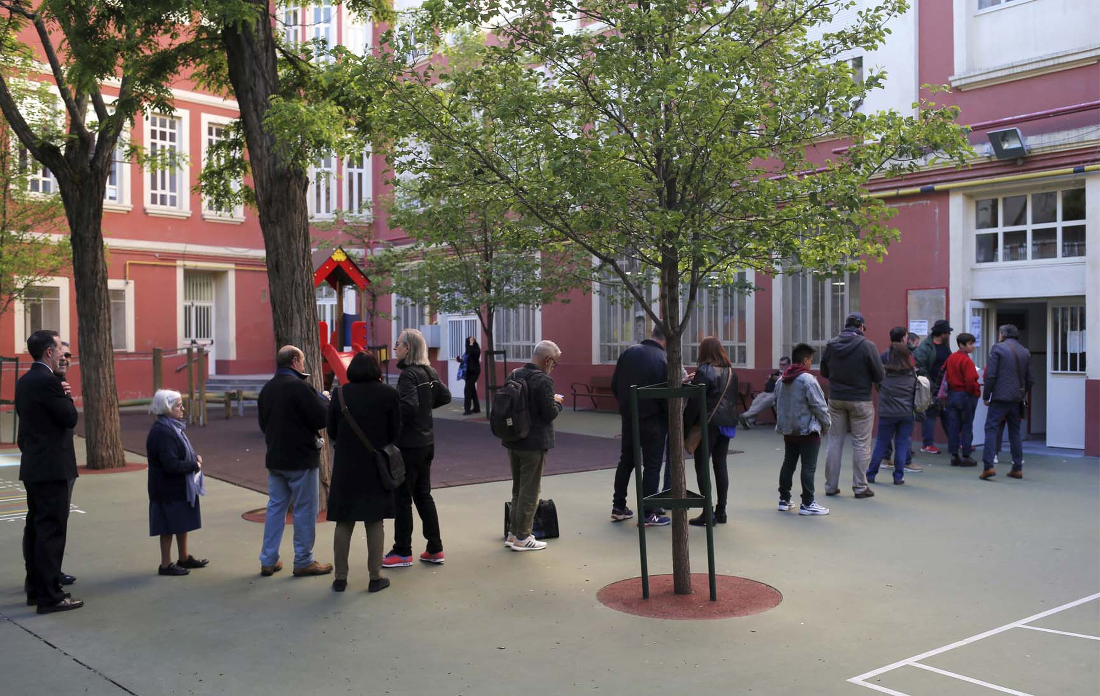 Votantes haciendo cola para entrar en el colegio electoral.