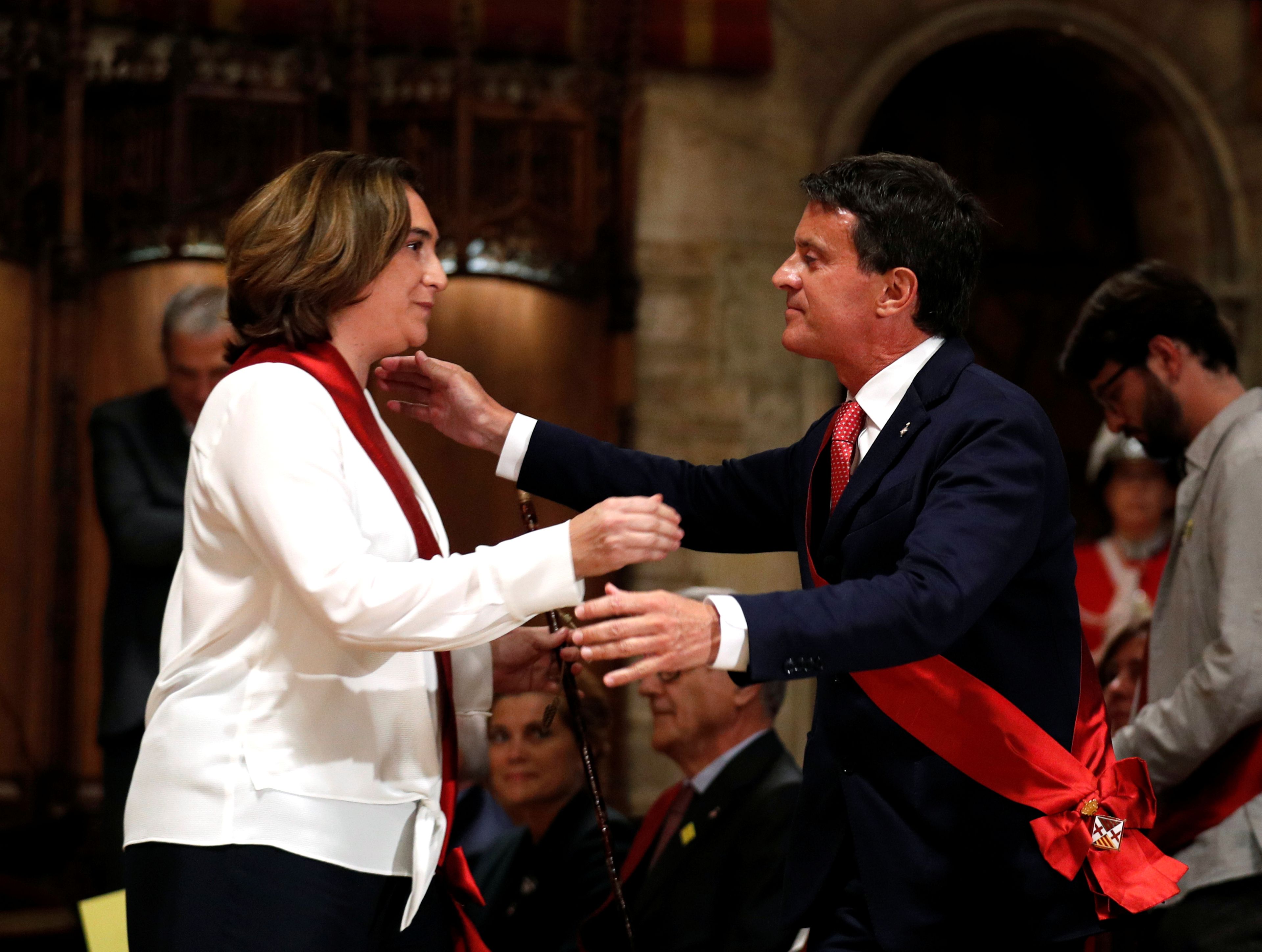 Ada Colau y Manuel Valls se saludan durante la sesión constitutiva del Ayuntamiento de Barcelona.