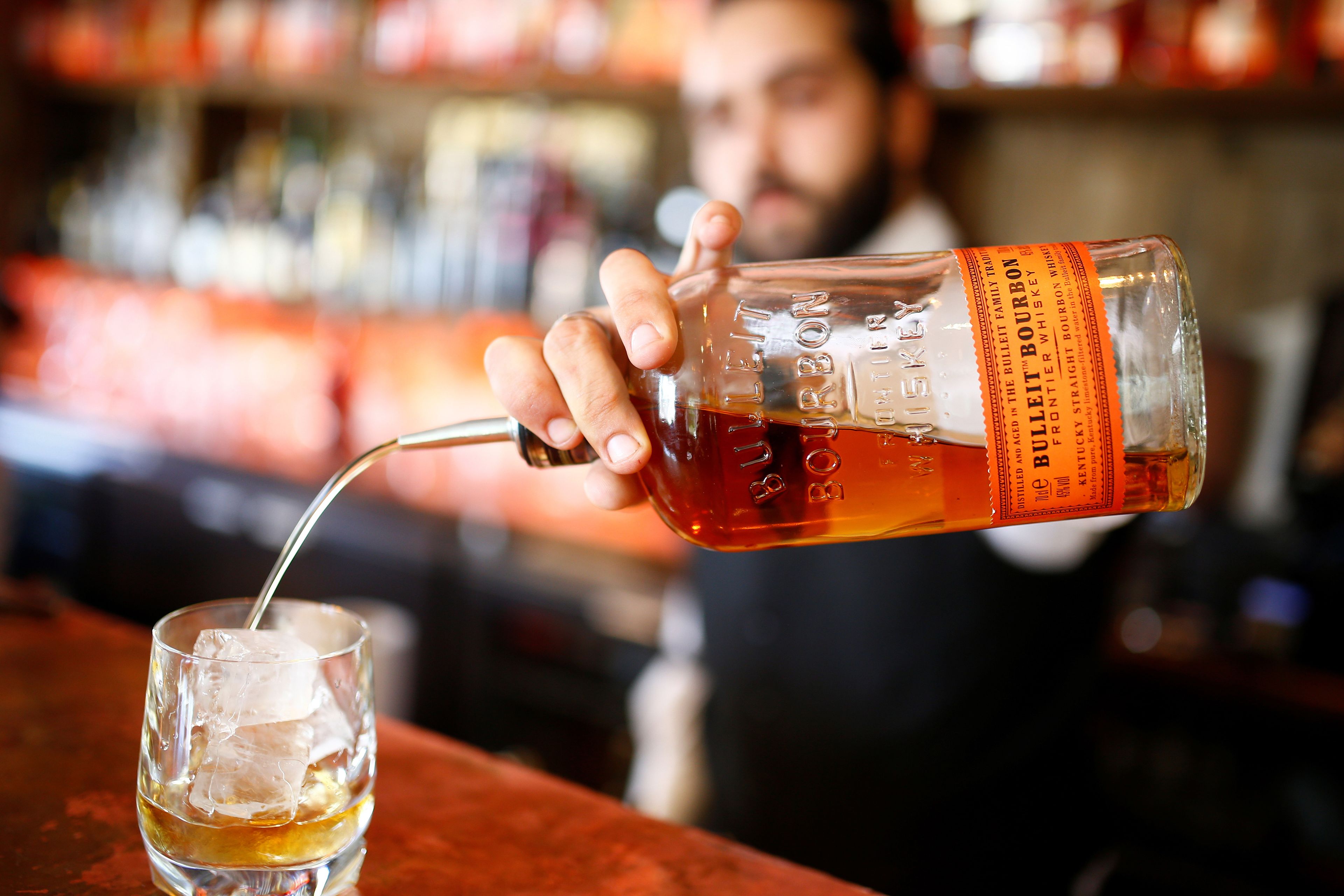 Un barista sirve una copa de whisky.