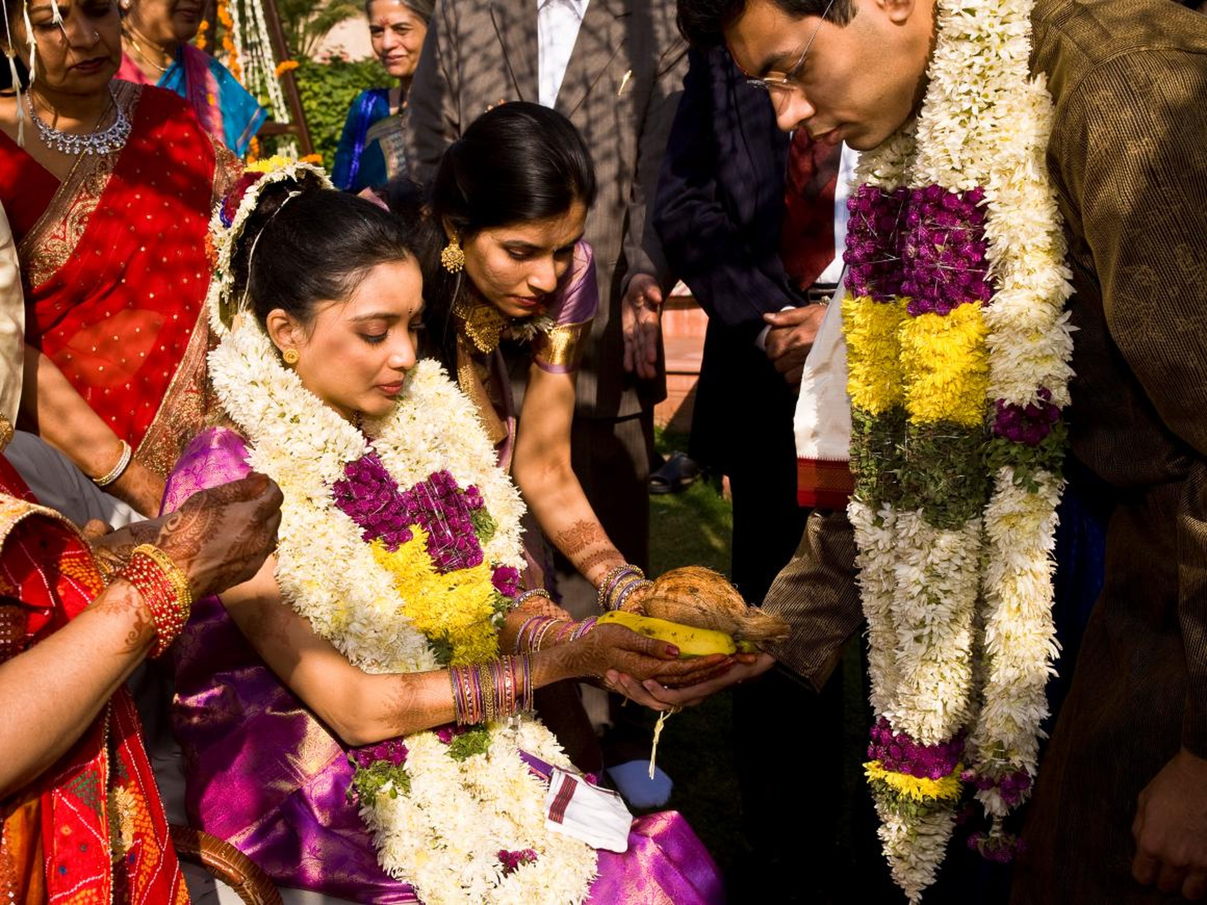 Aquí, la novia es rodeada por su familia durante un momento de oración antes de que su padre se la entregue al novio.