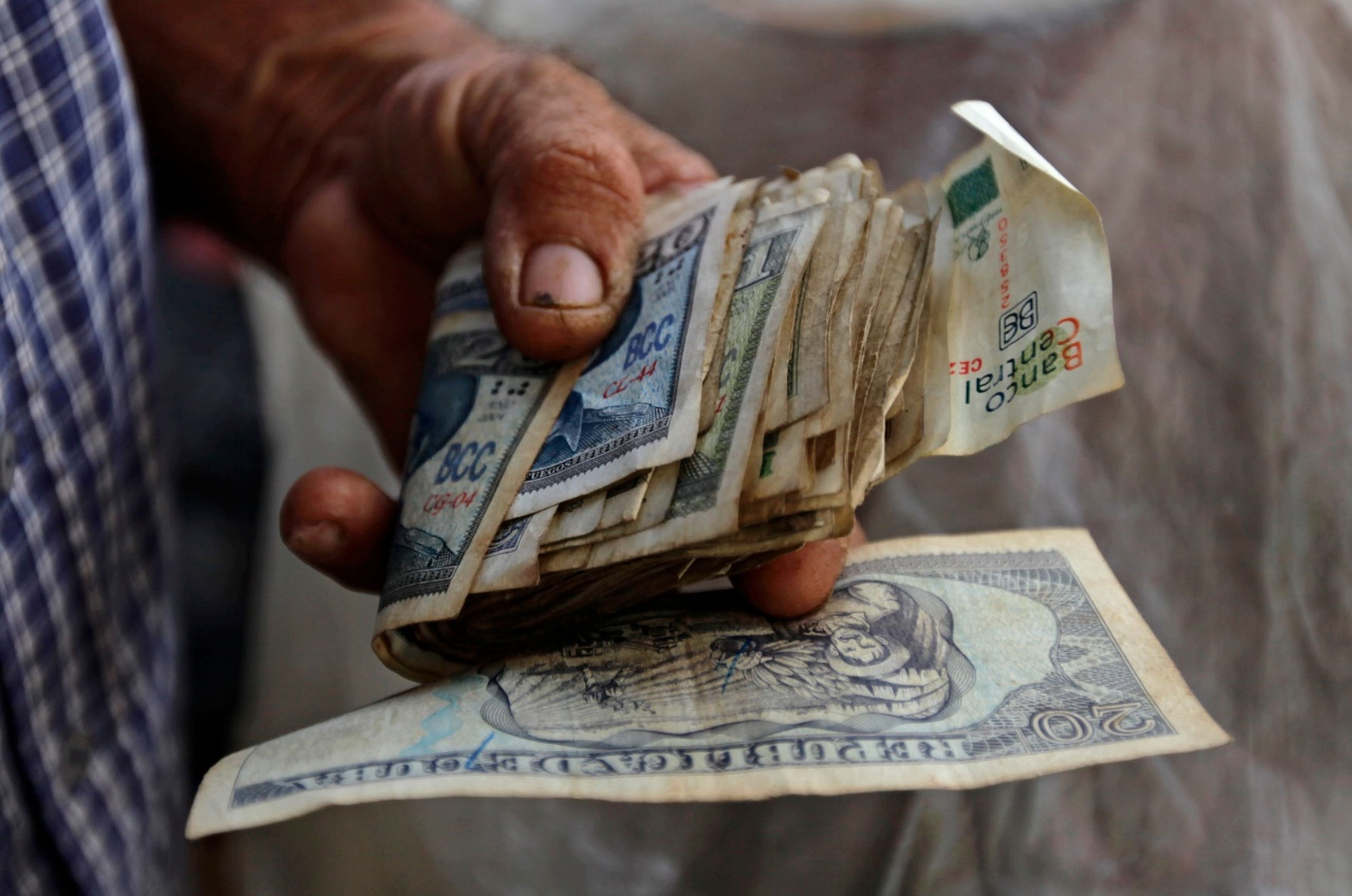 Un cubano con un fajo de billetes en la mano